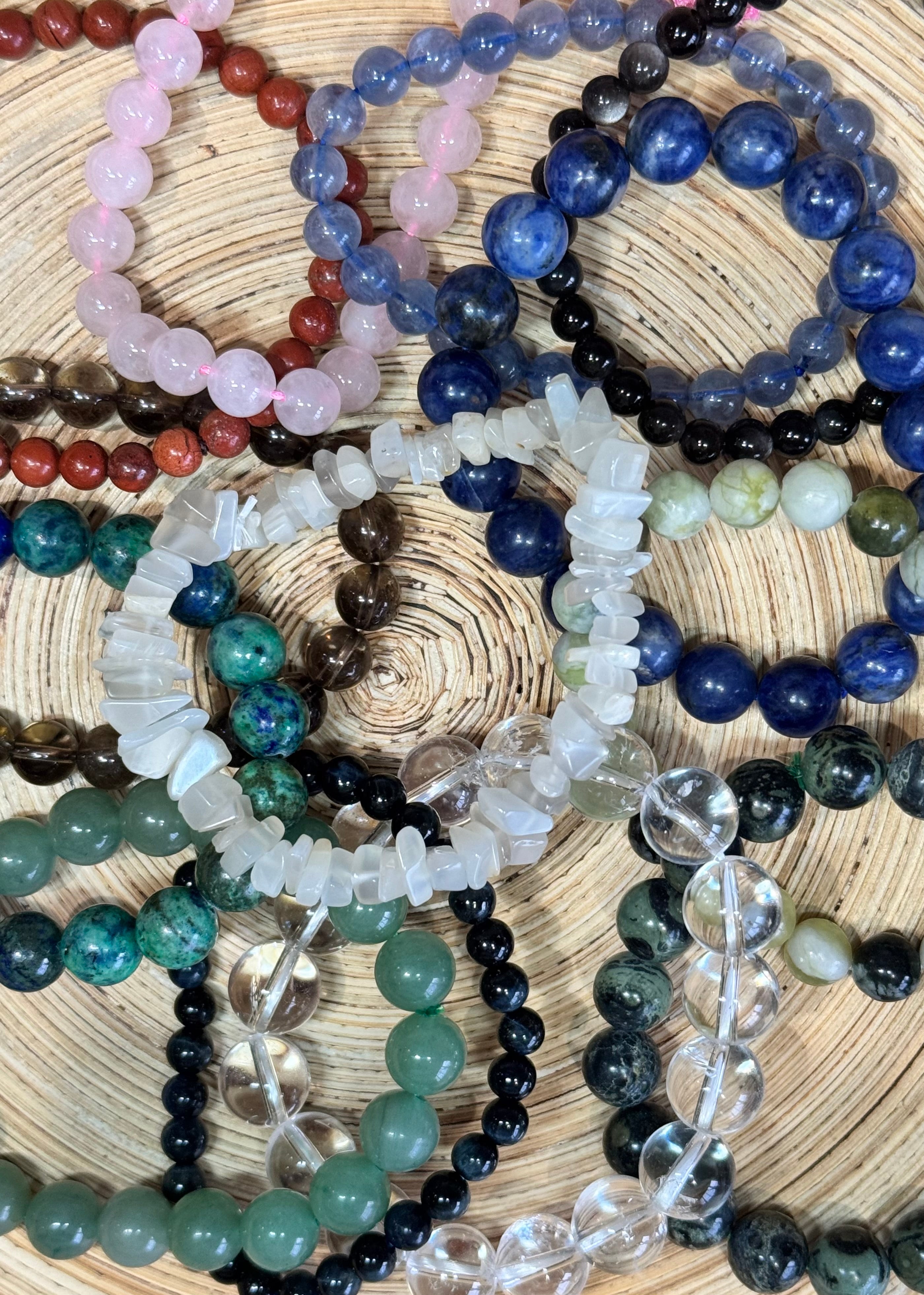 collection of many beaded crystal bracelets on a wooden background