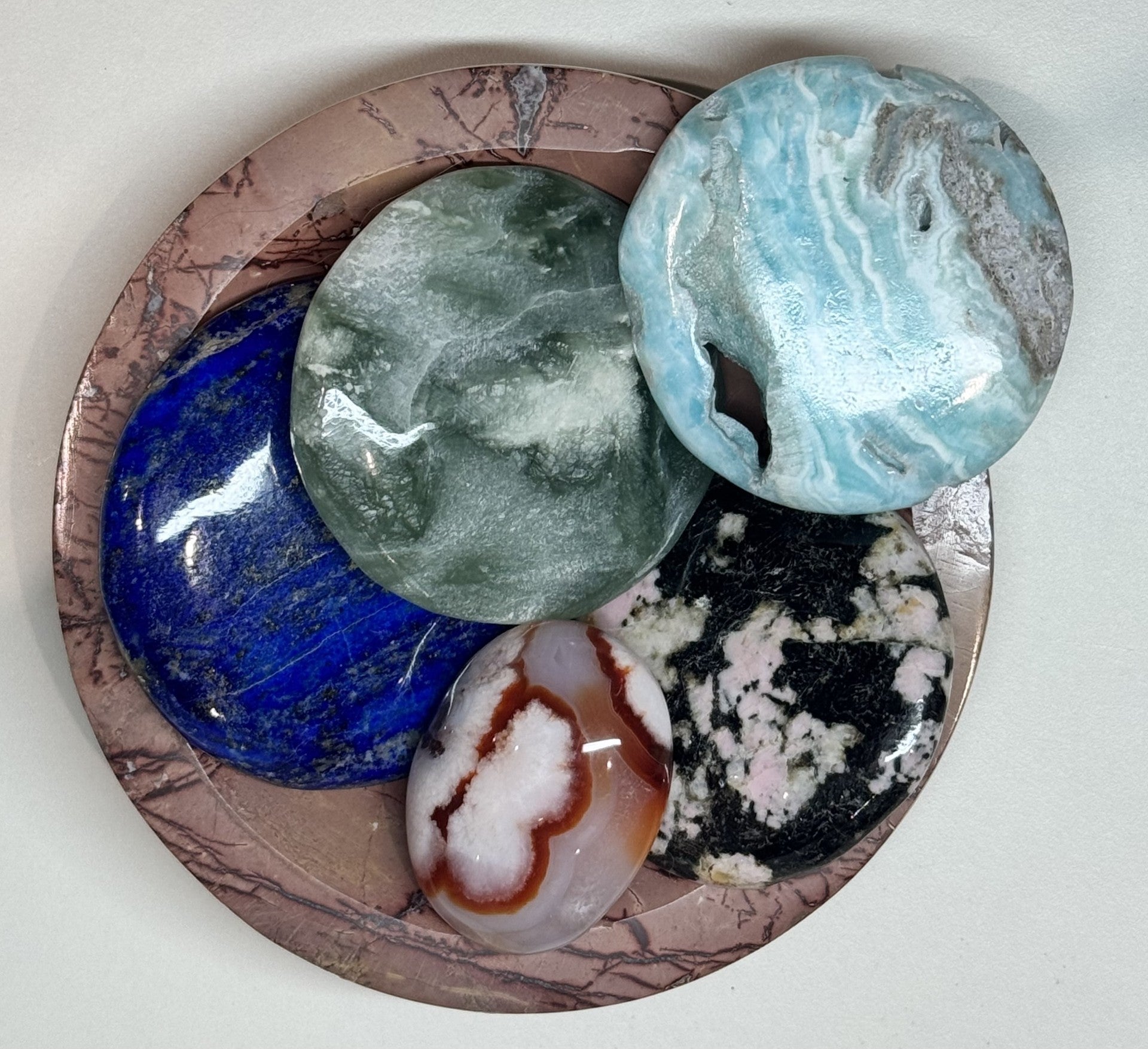 5 round flat stones in a pink/brown stone bowl