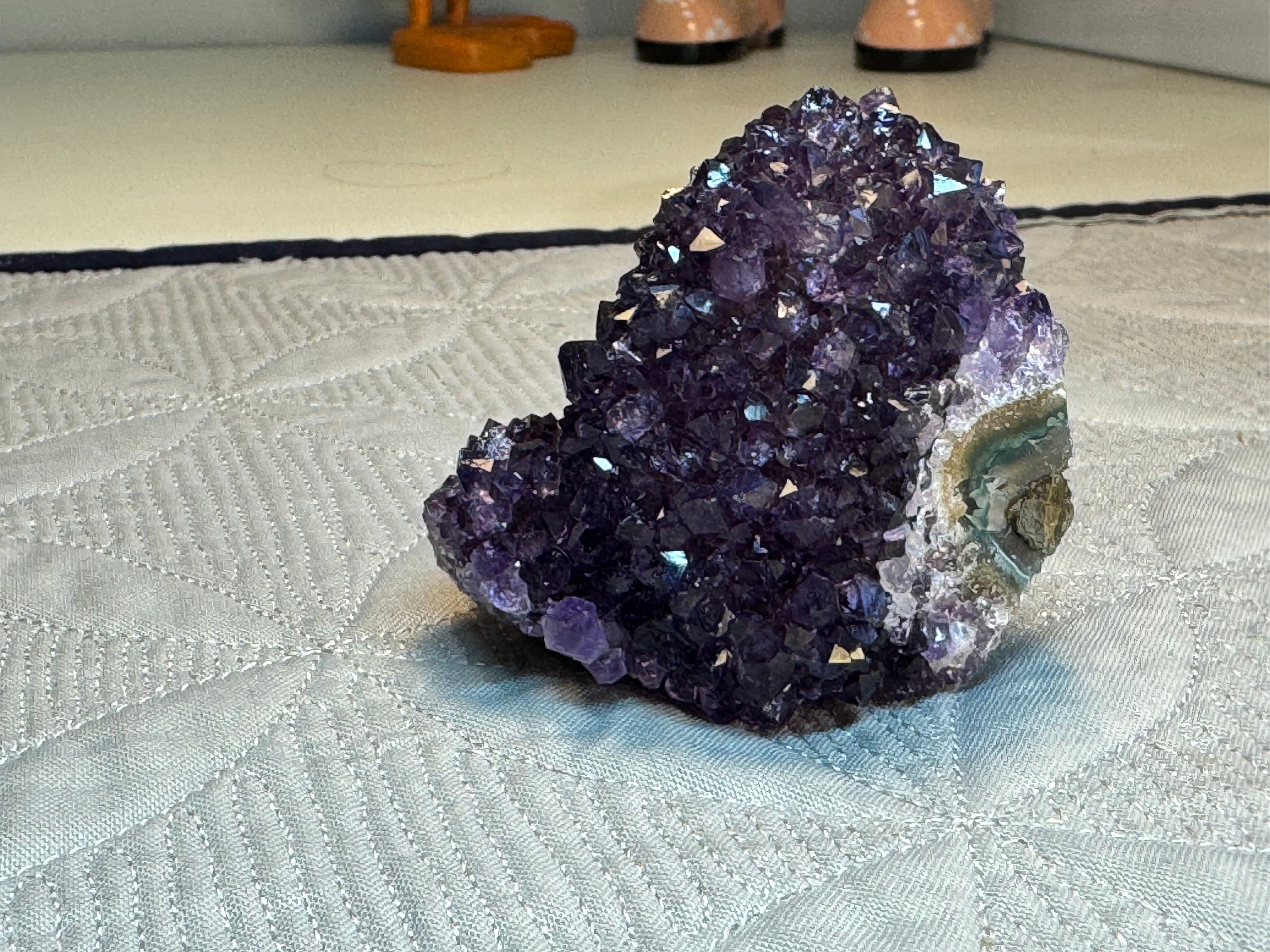 Amethyst crystal cluster on a textured surface