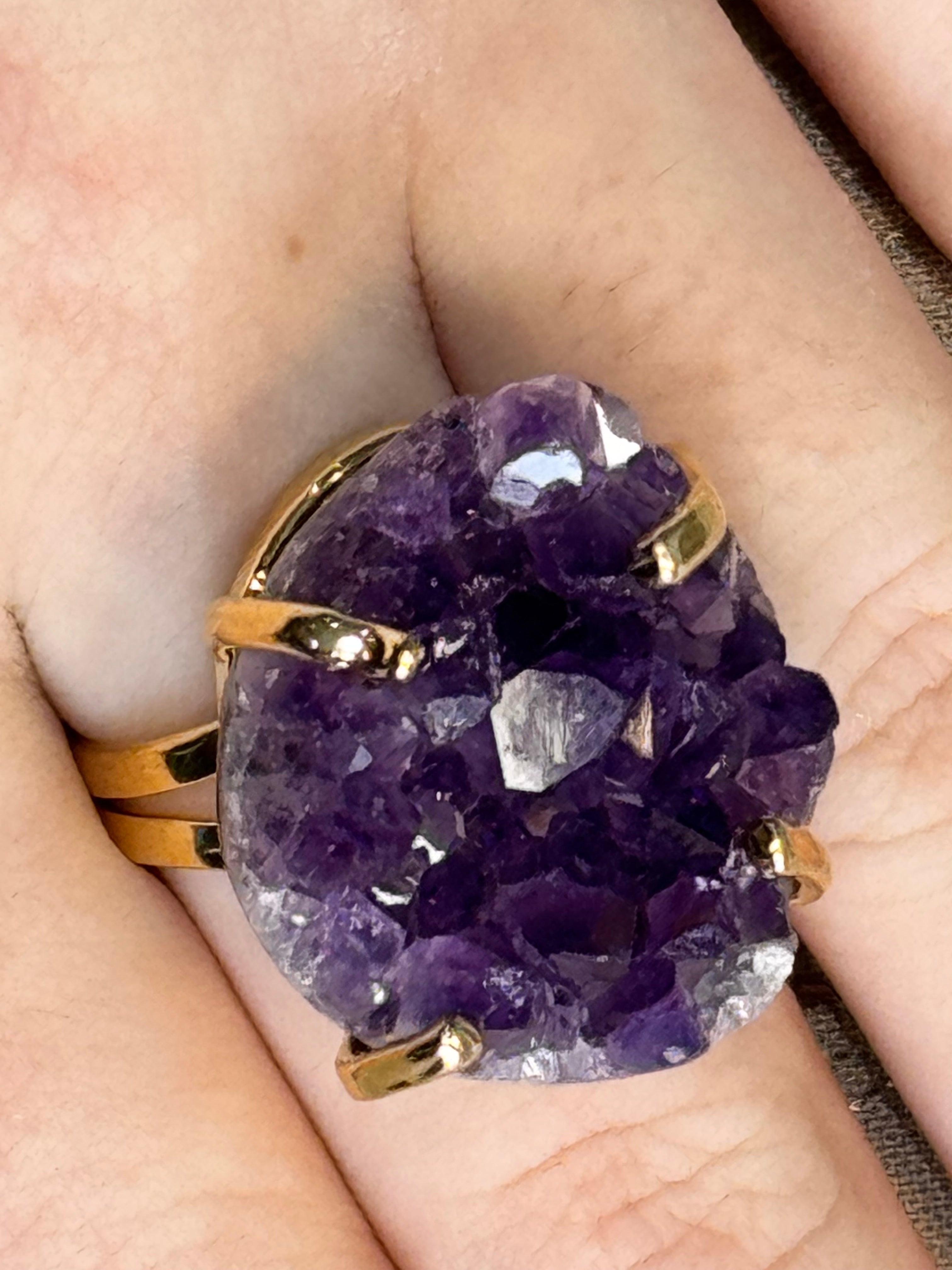 Ring with purple crystal and gold setting on a hand