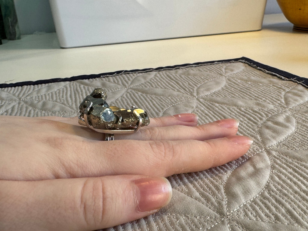 Small decorative item on a finger with a quilted fabric background