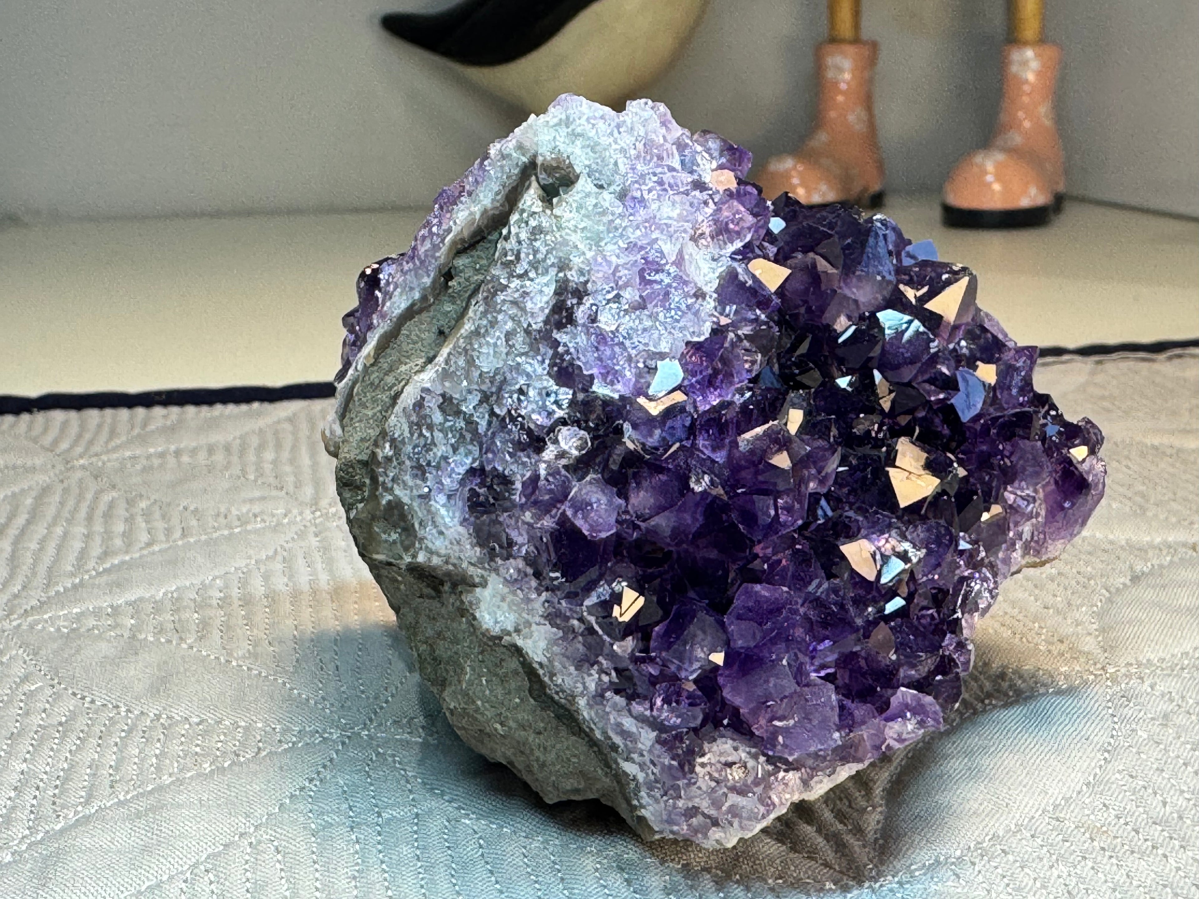 Amethyst crystal cluster on a textured surface with blurred background