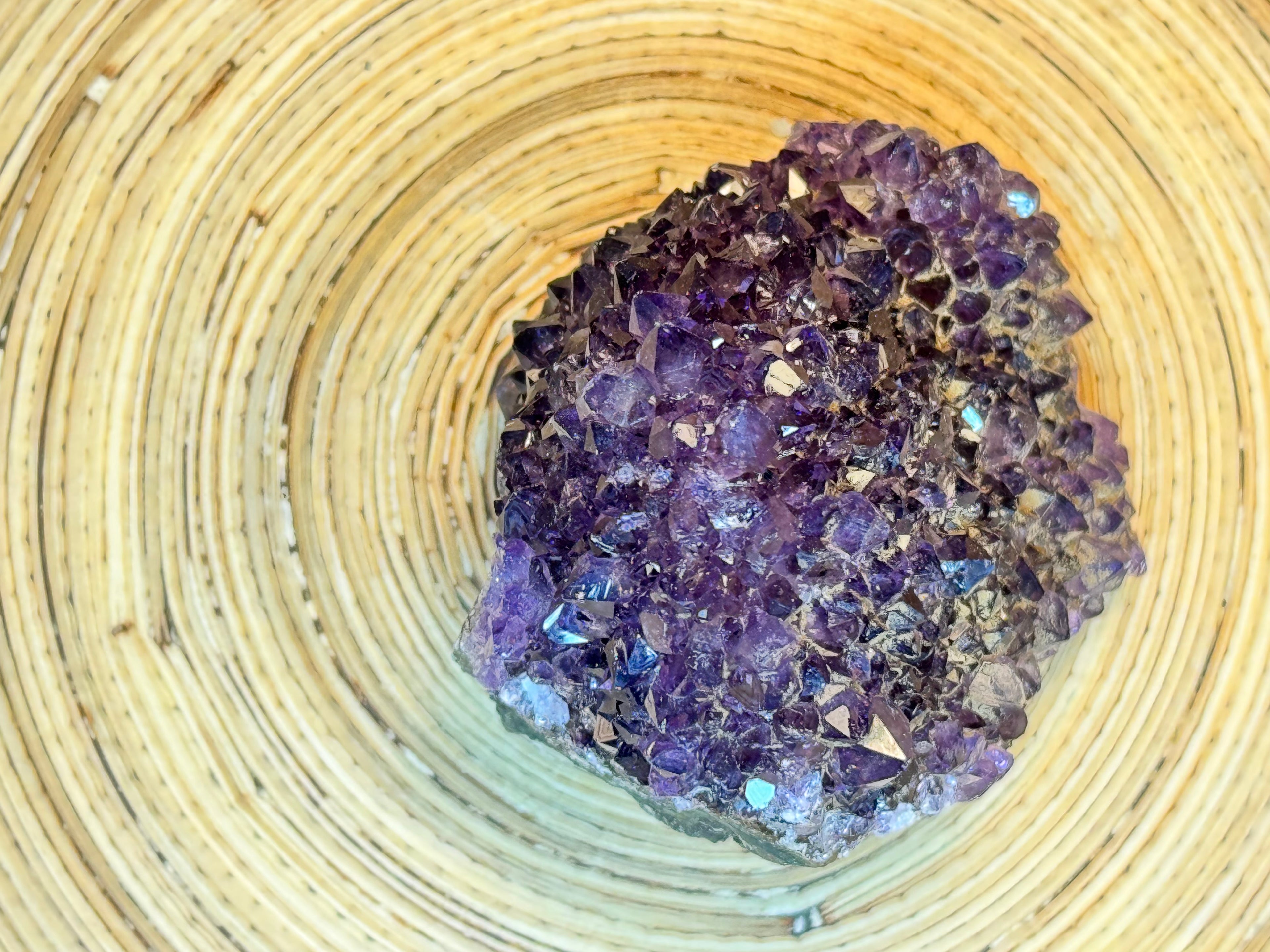 Amethyst crystal cluster on a woven surface