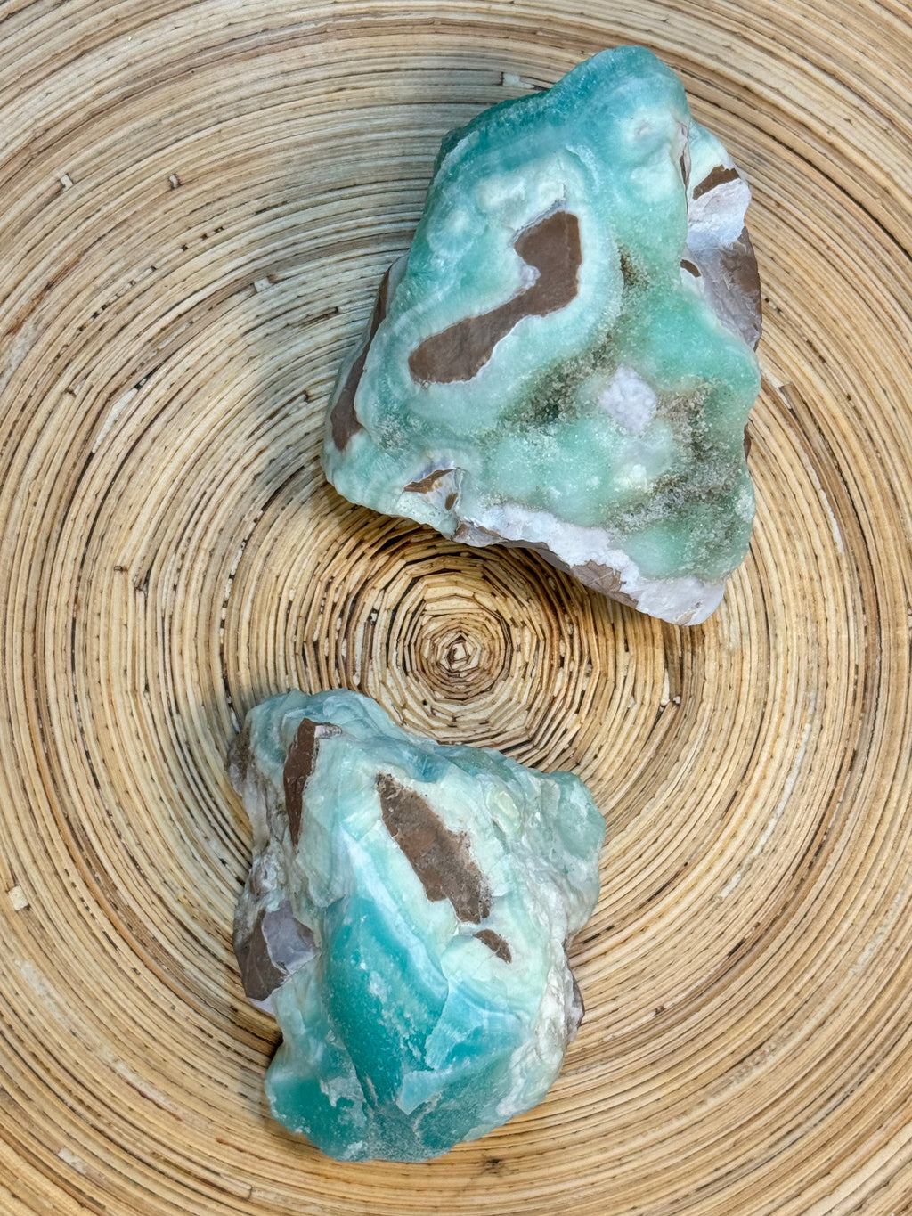 Two turquoise-colored rocks on a woven surface