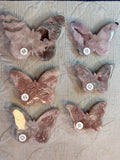 Butterfly-shaped rocks with numbers on a textured surface