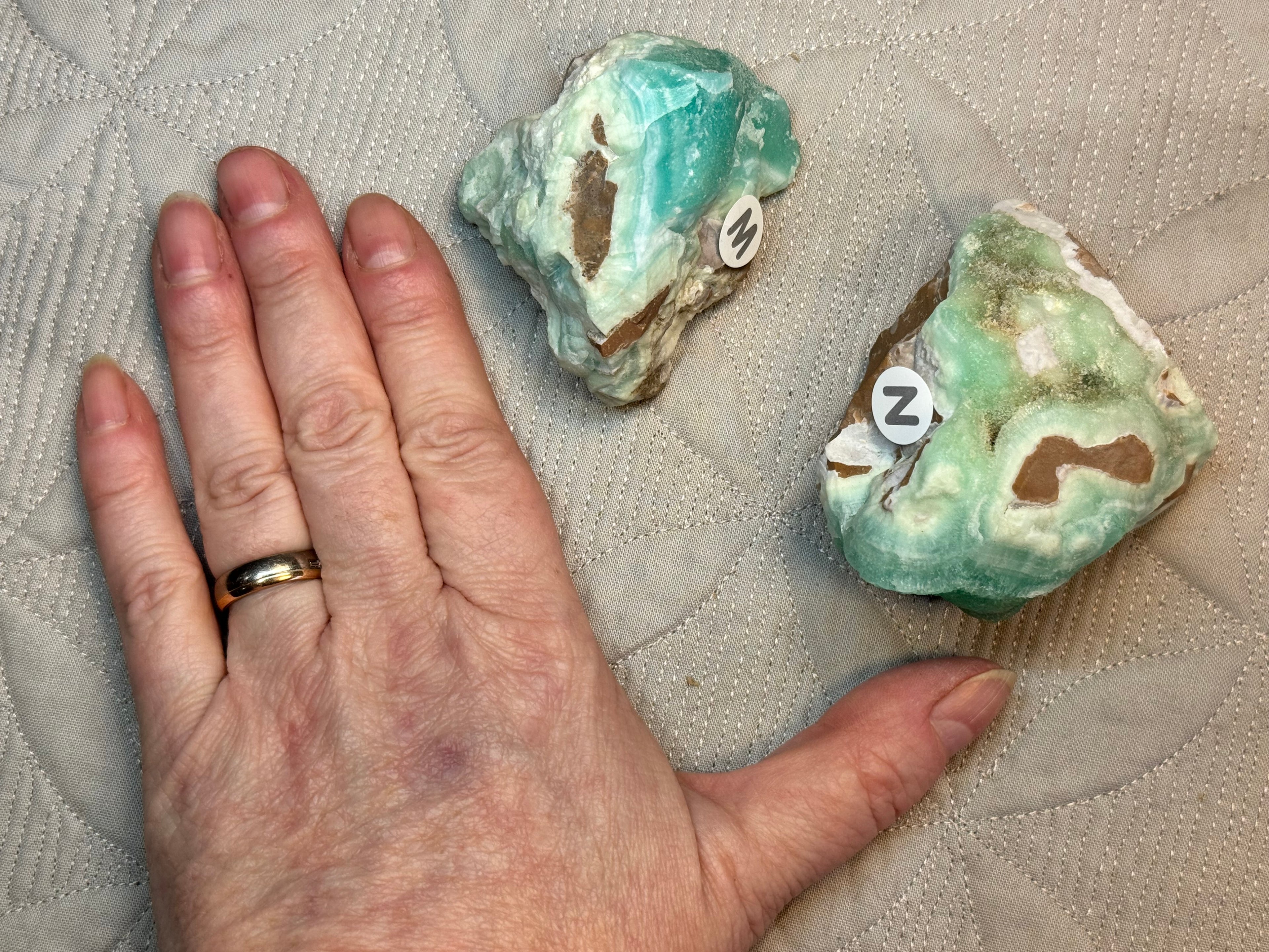 Hand with a ring next to two green crystals