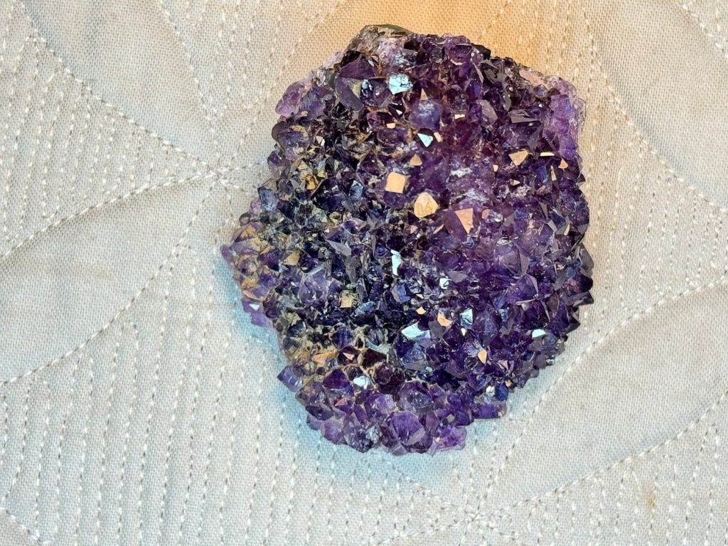Amethyst crystal on a textured white surface
