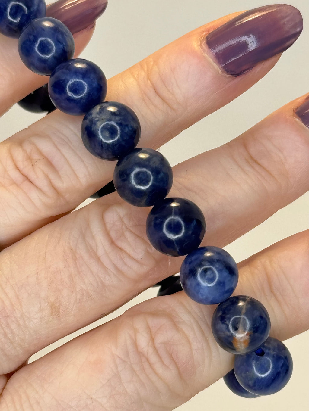 Navy blue beaded bracelet on a hand with a neutral background