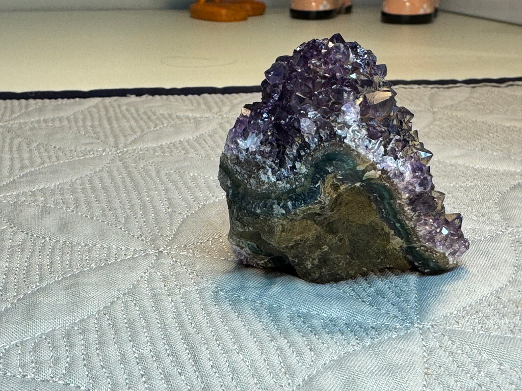 Amethyst crystal cluster on a textured surface
