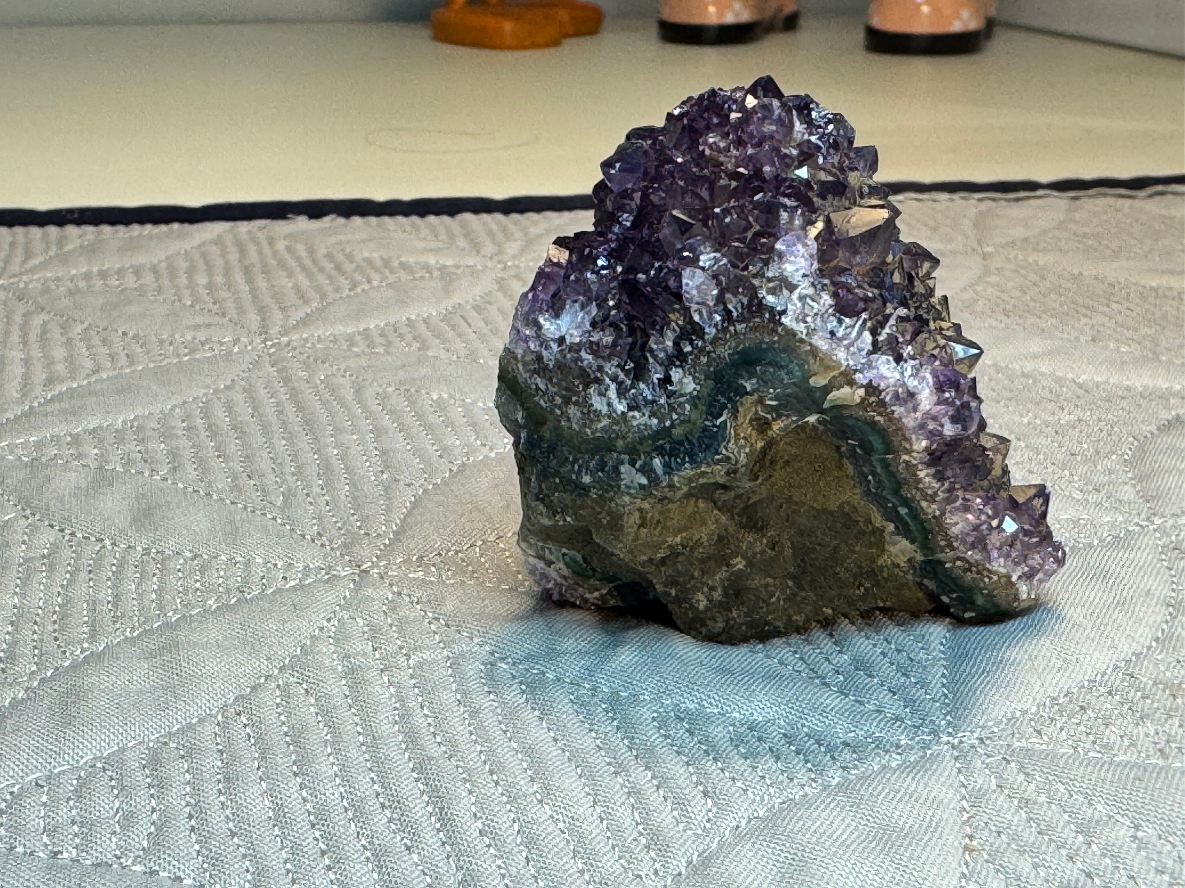Amethyst crystal cluster on a textured surface