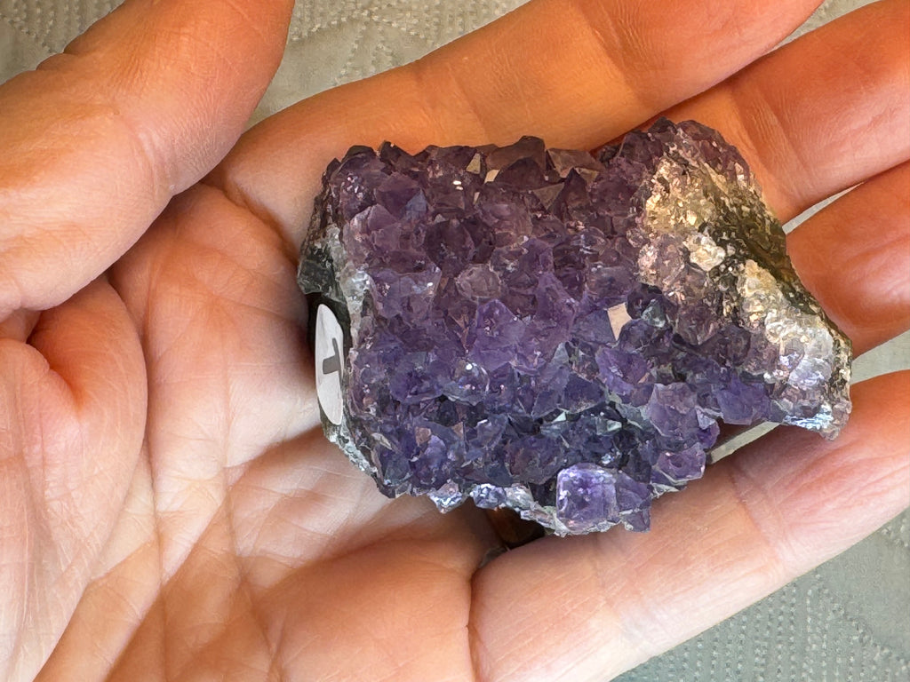 Hand holding a purple crystal rock