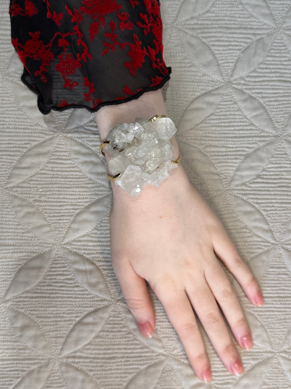Hand wearing a bracelet on a textured surface