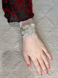 Hand wearing a bracelet on a textured surface