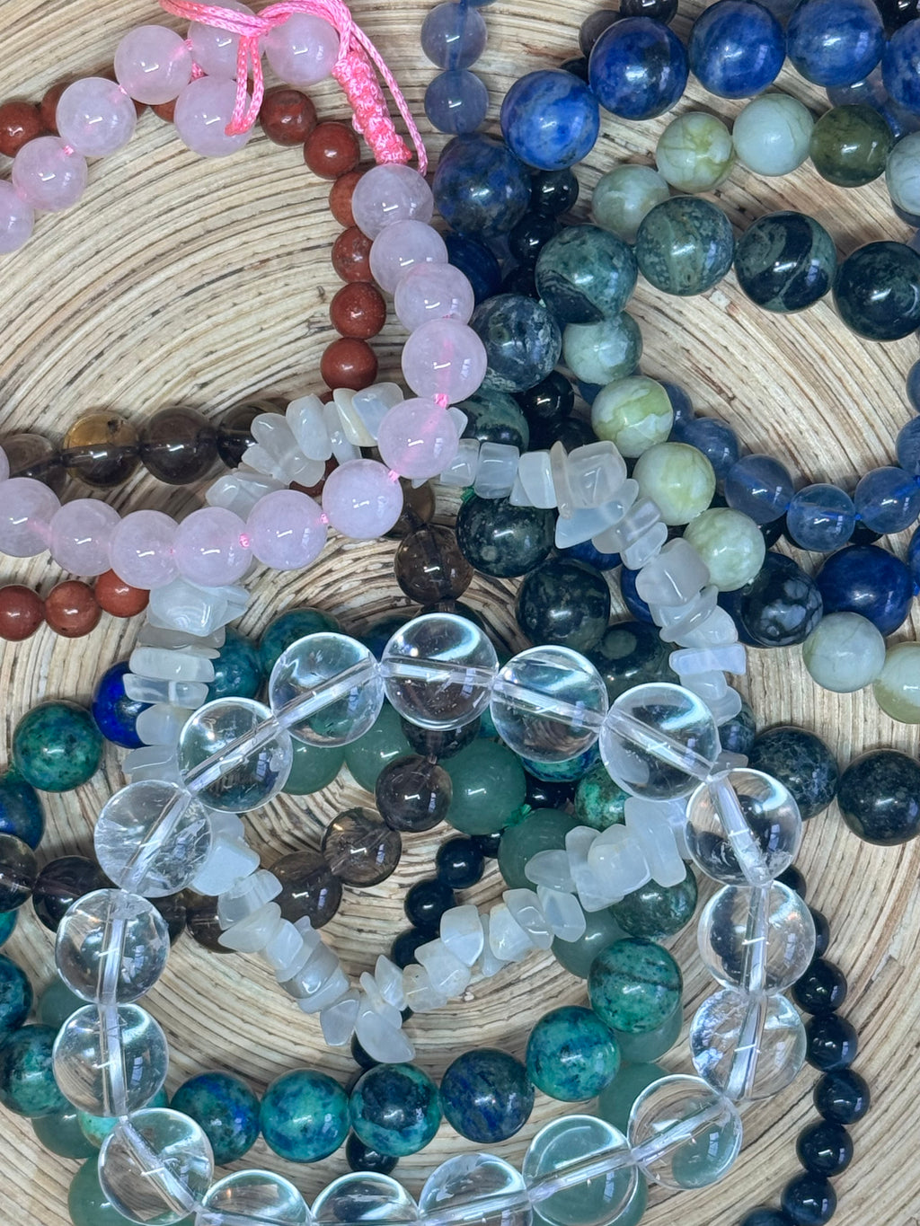Collection of multicolored beaded bracelets on a woven surface