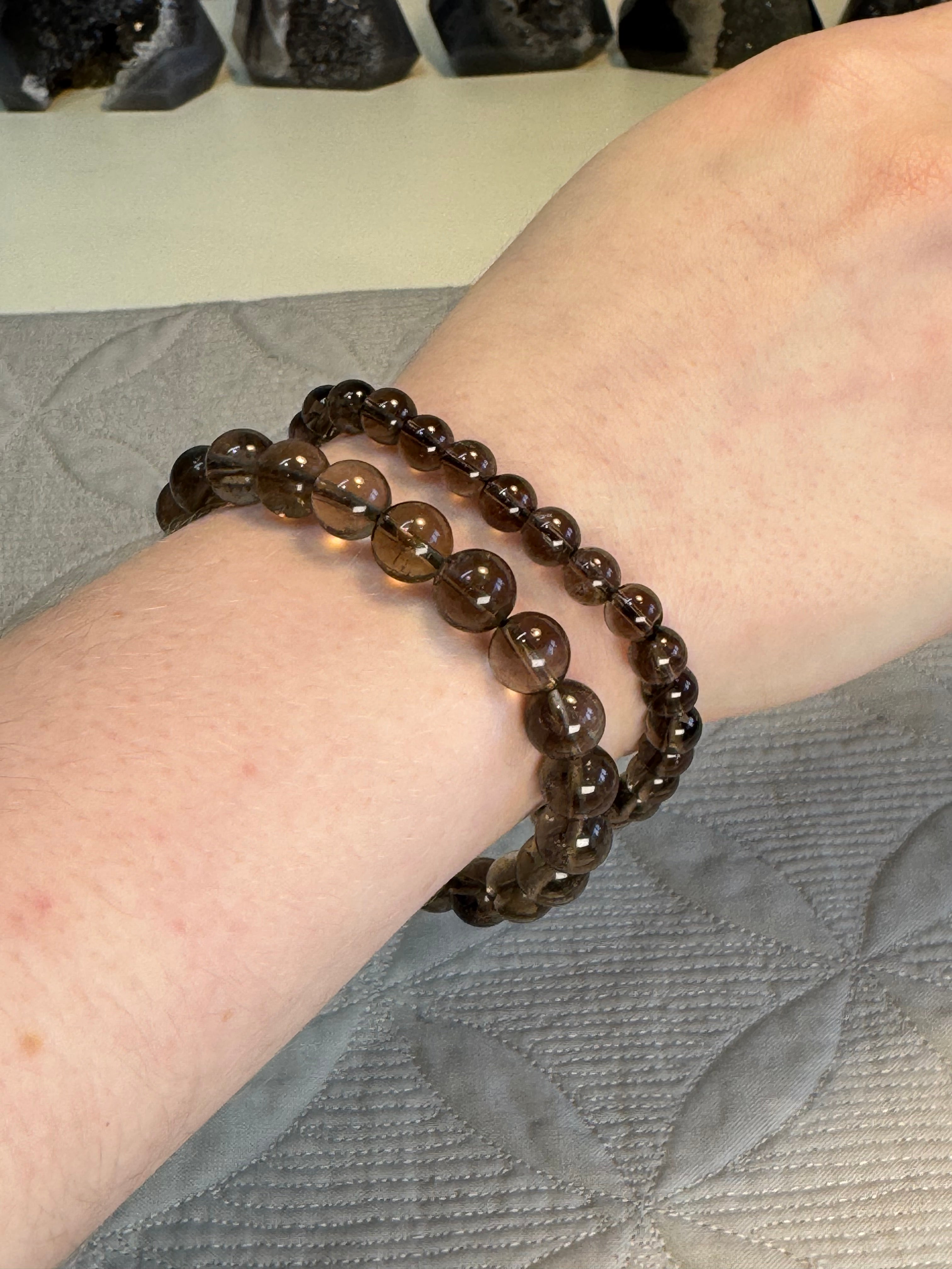 Brown beaded bracelet on a wrist with a neutral background