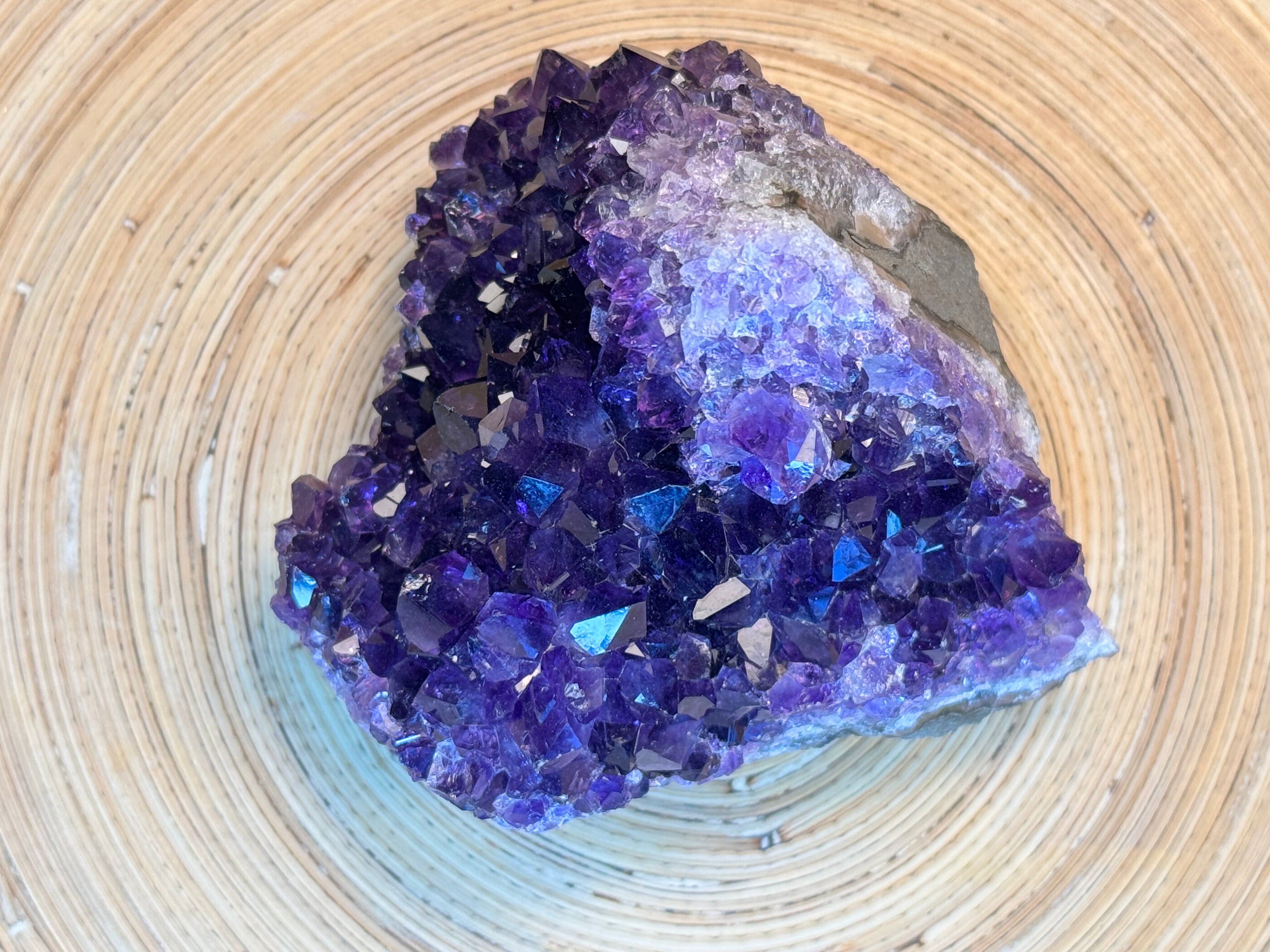 Amethyst crystal cluster on a woven surface