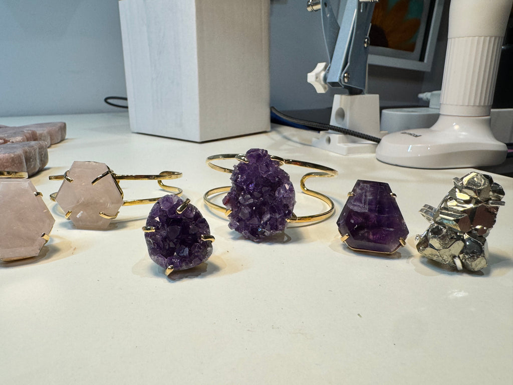 Amethyst crystal jewelry on a white surface with a blurred background