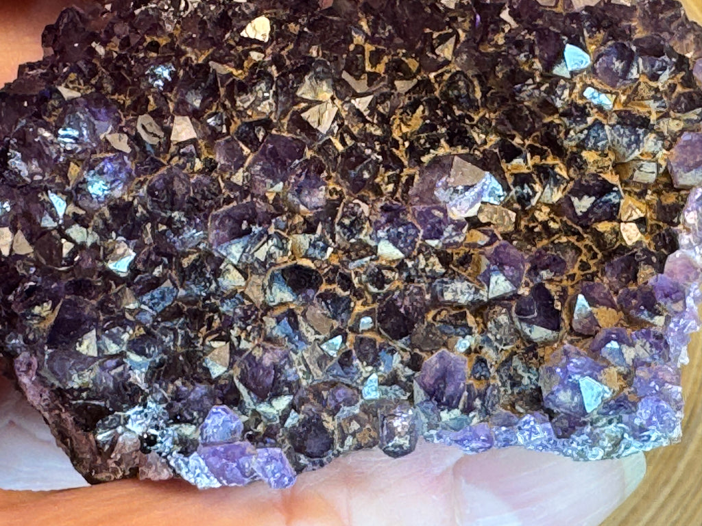 Close-up of a crystal rock with purple crystals with iron inclusions