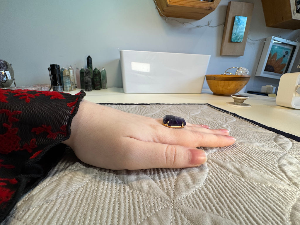Hand resting on a textured surface with a blurred indoor background