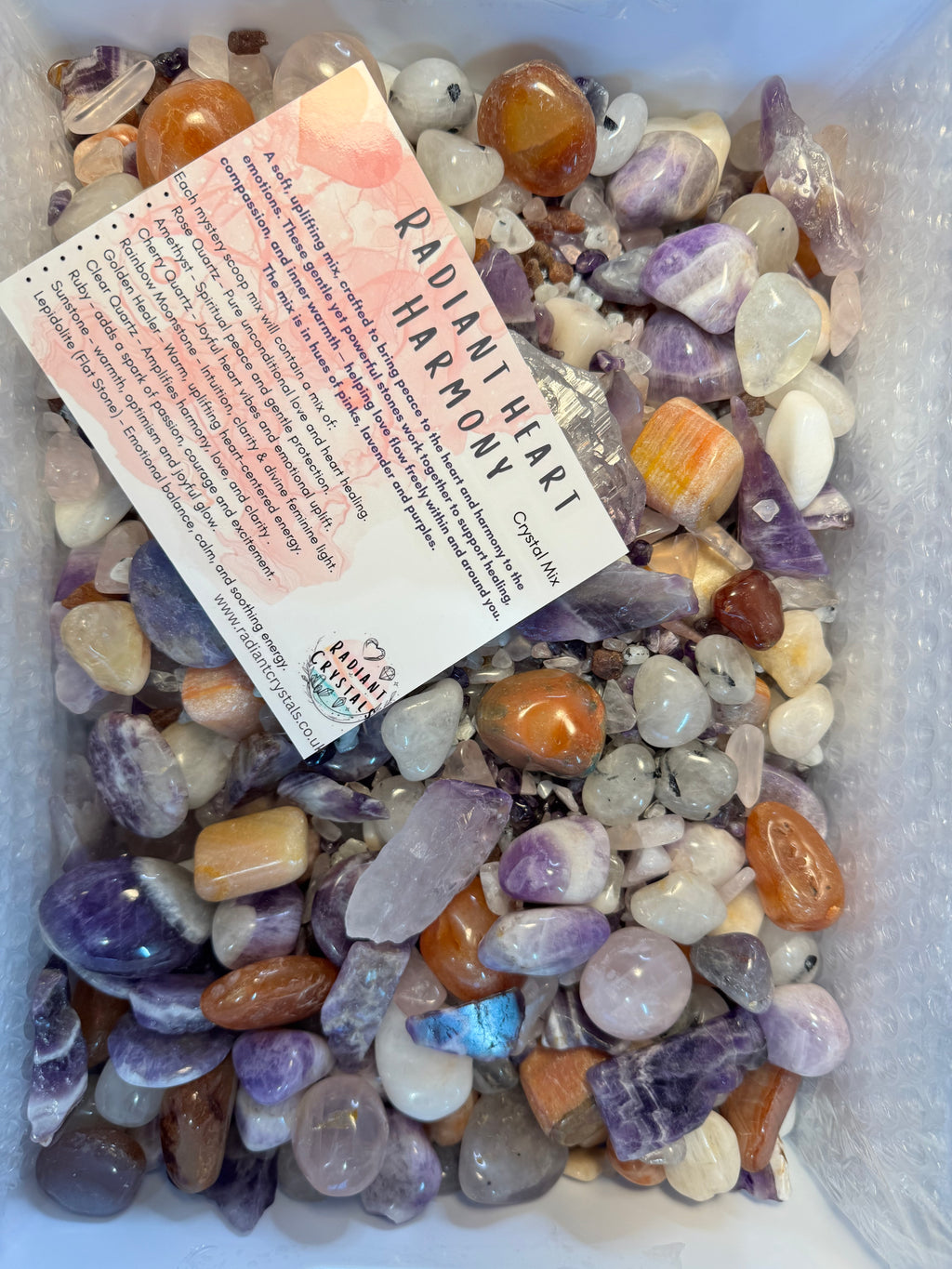 Assorted colorful crystals in a box with a 'Radiant Heart Harmony' card.