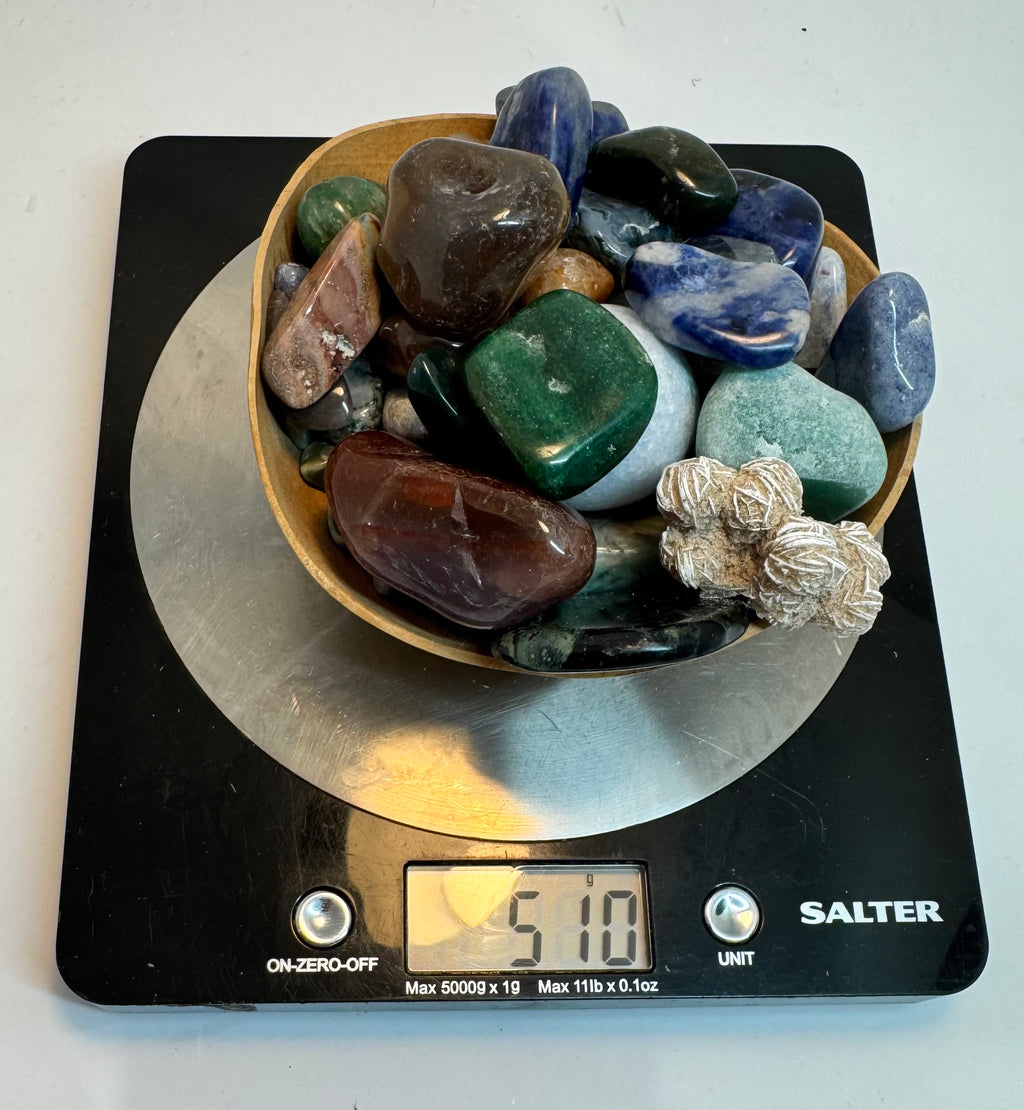 Bowl of multicolored stones on a Salter scale displaying a weight.