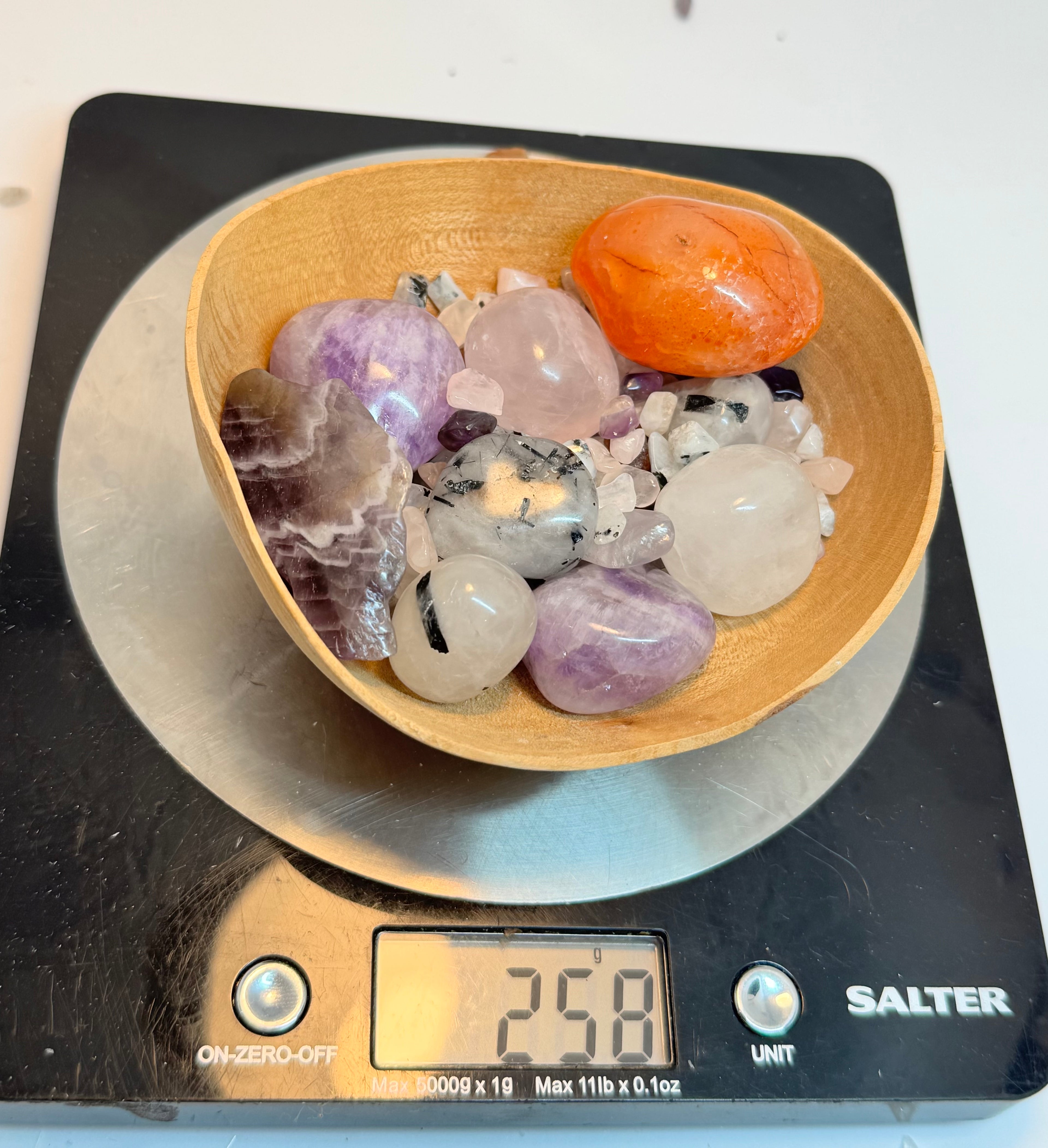 Bowl of multicolored crystals on a Salter digital scale displaying weight.