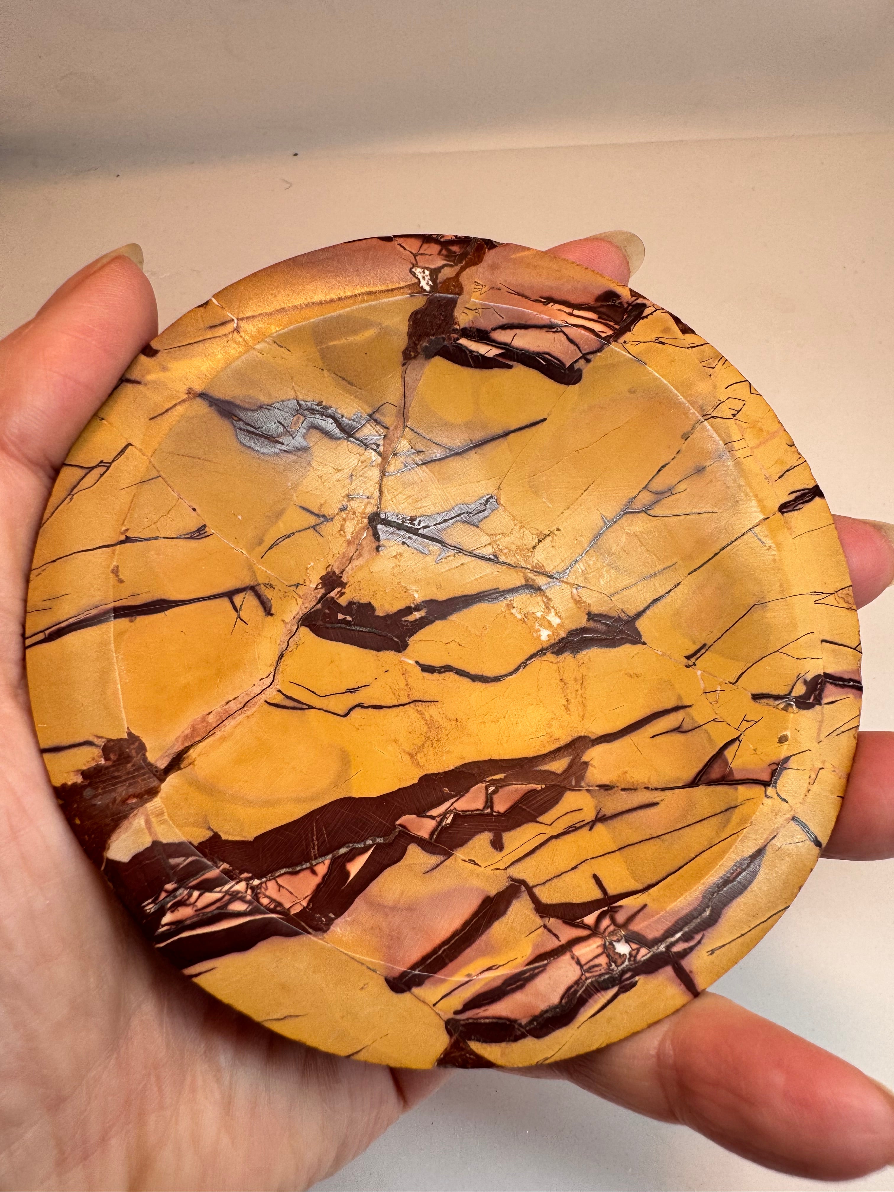 Marbled stone held in a hand against a neutral background