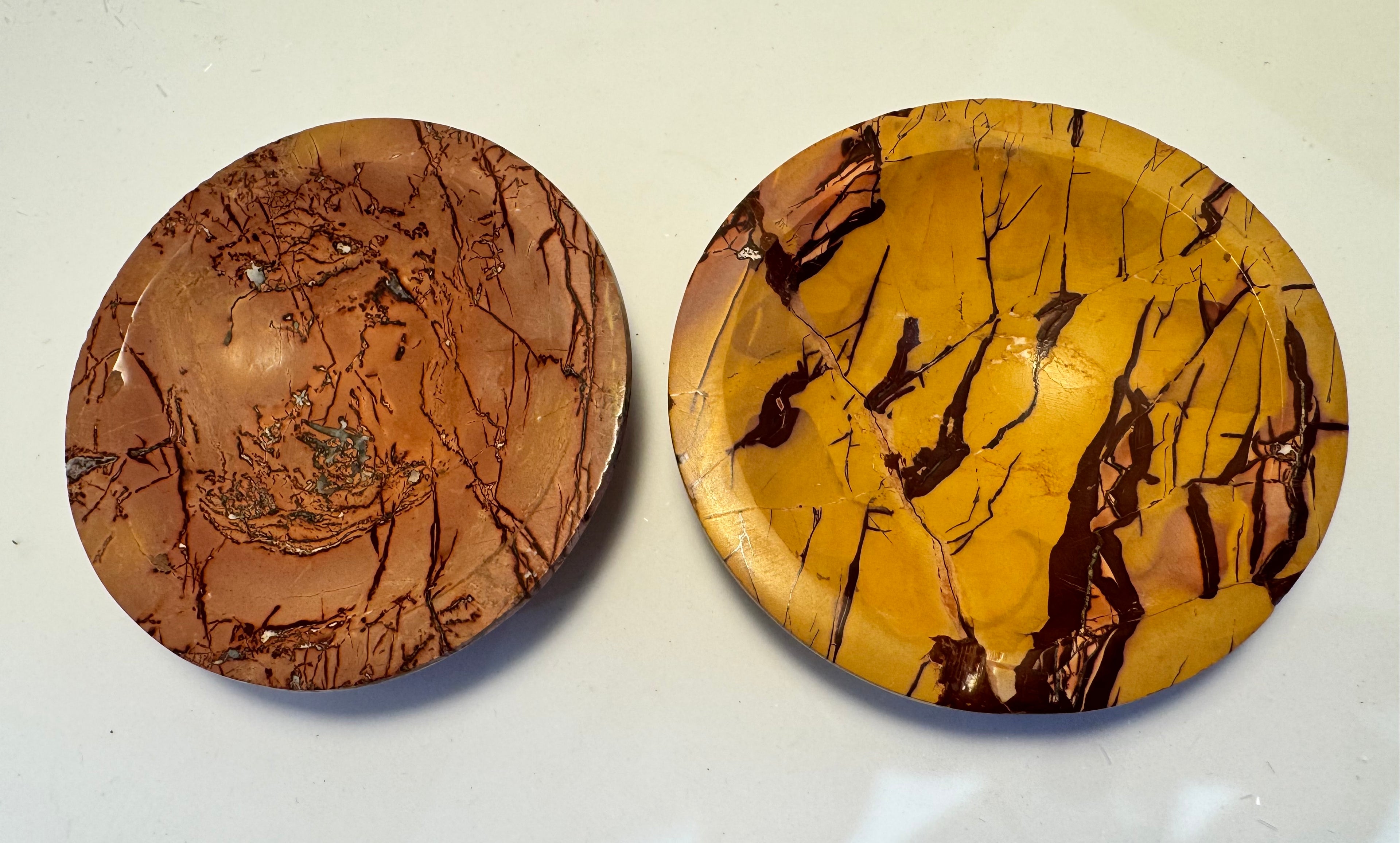 Two round mineral plates with marbled patterns on a white background