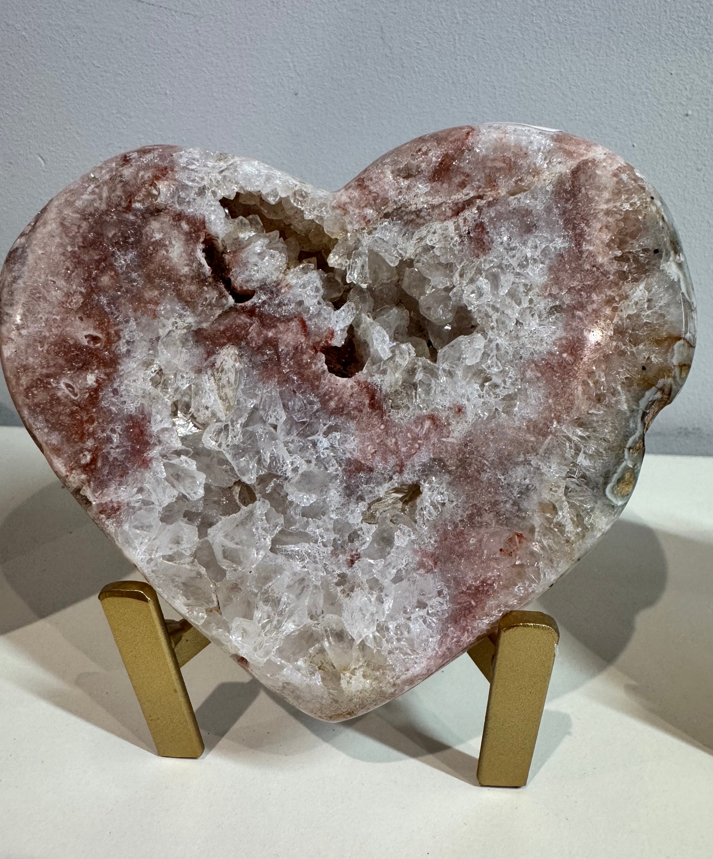 Heart-shaped crystal on a stand against a gray background