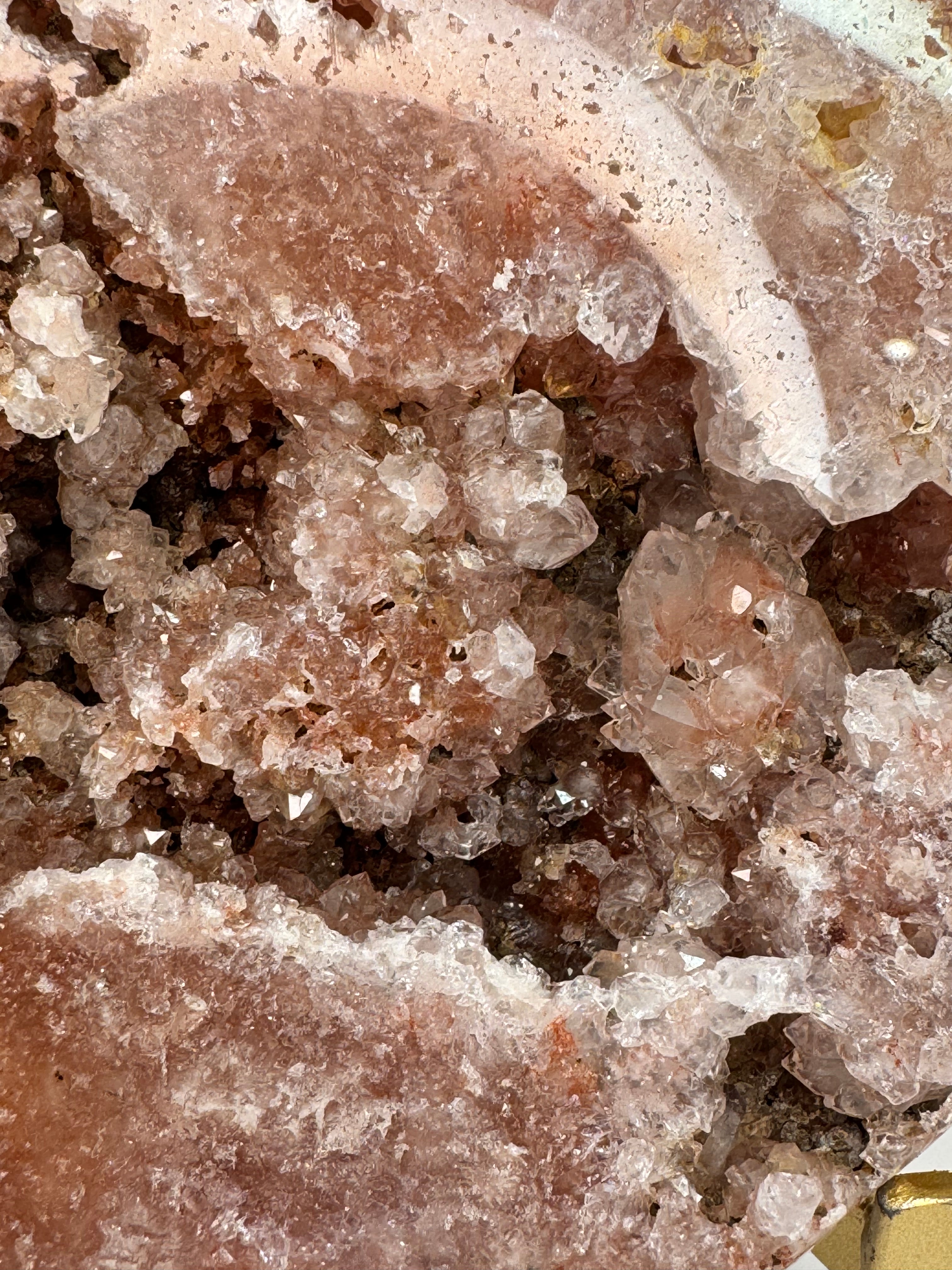 Close-up of crystalline mineral formation with a gold object in the corner