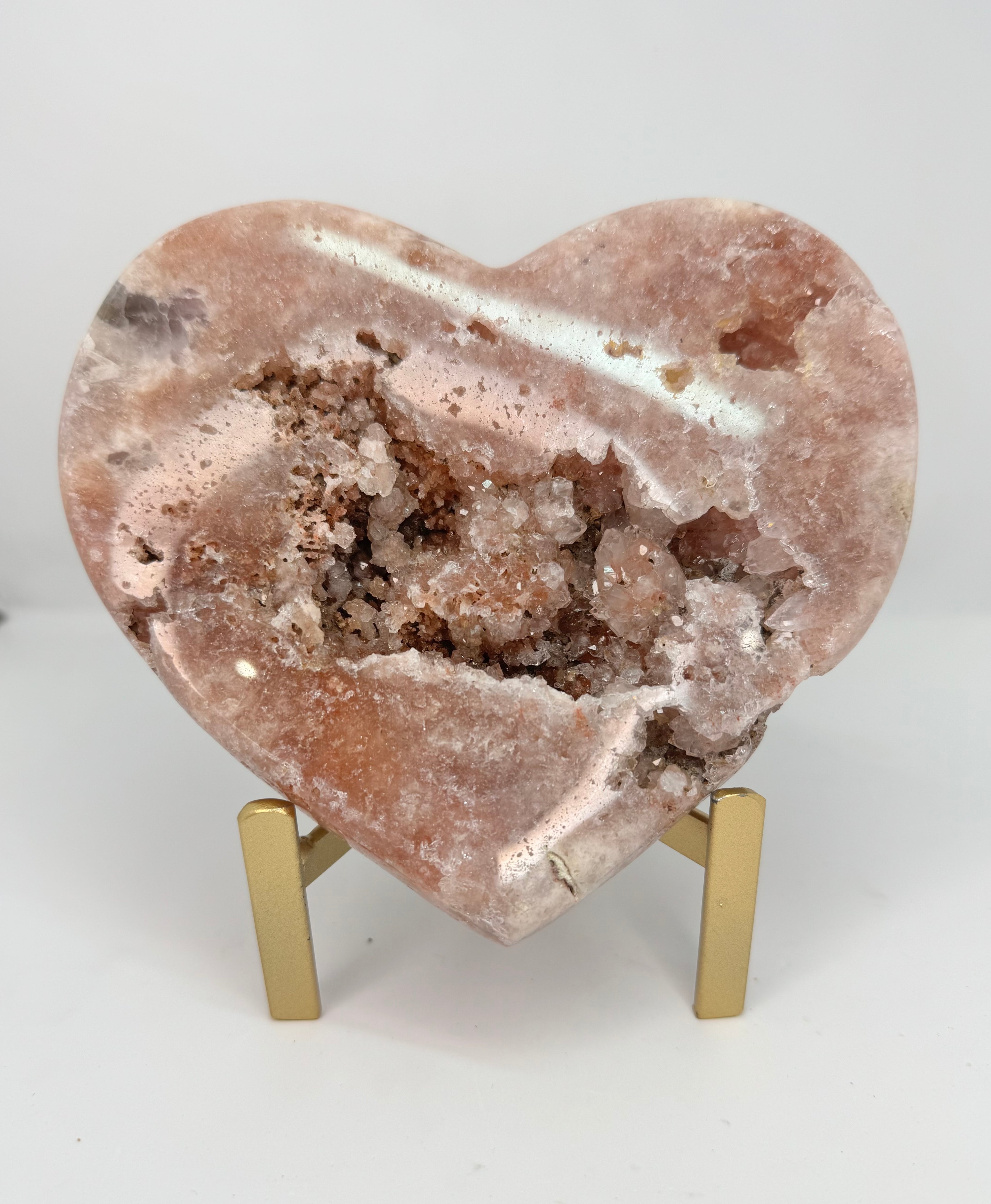 Heart-shaped crystal on a stand with a white background