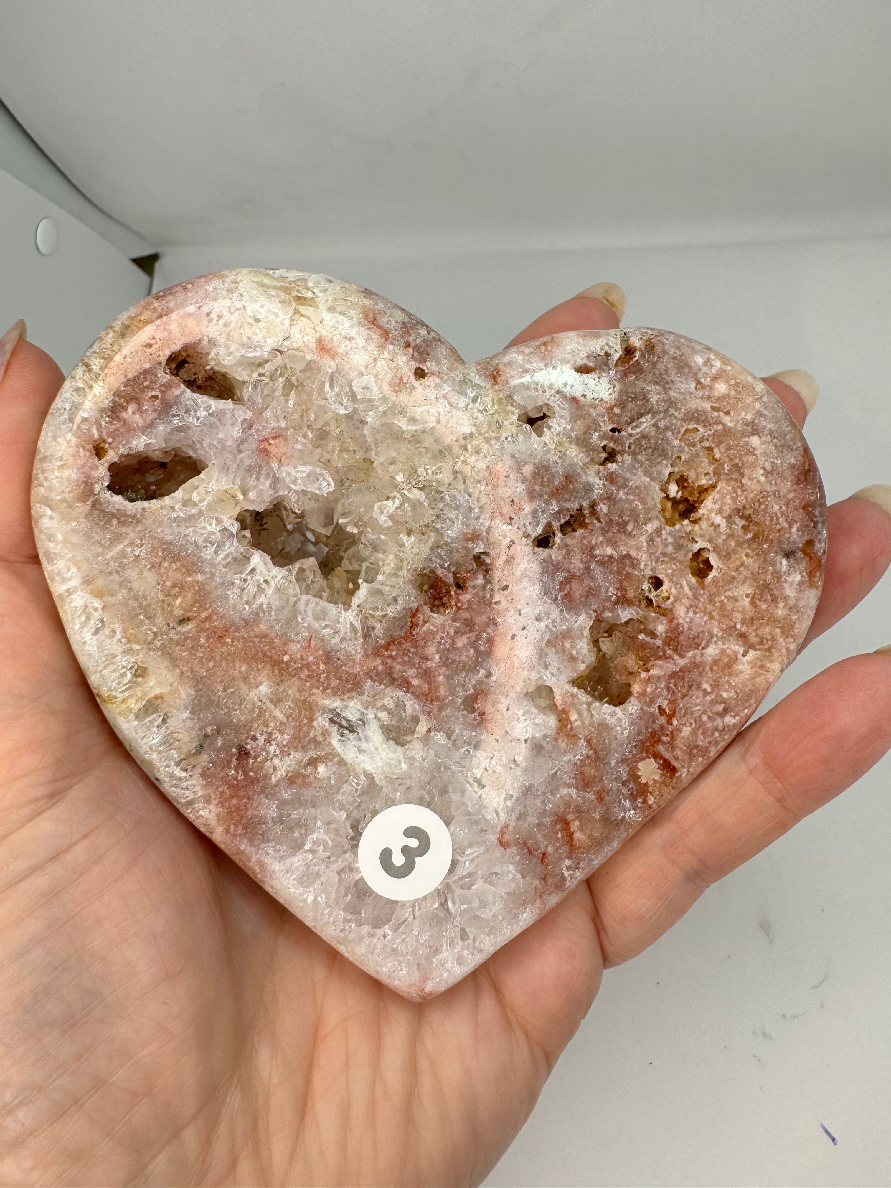Hand holding a large crystal rock with a white background