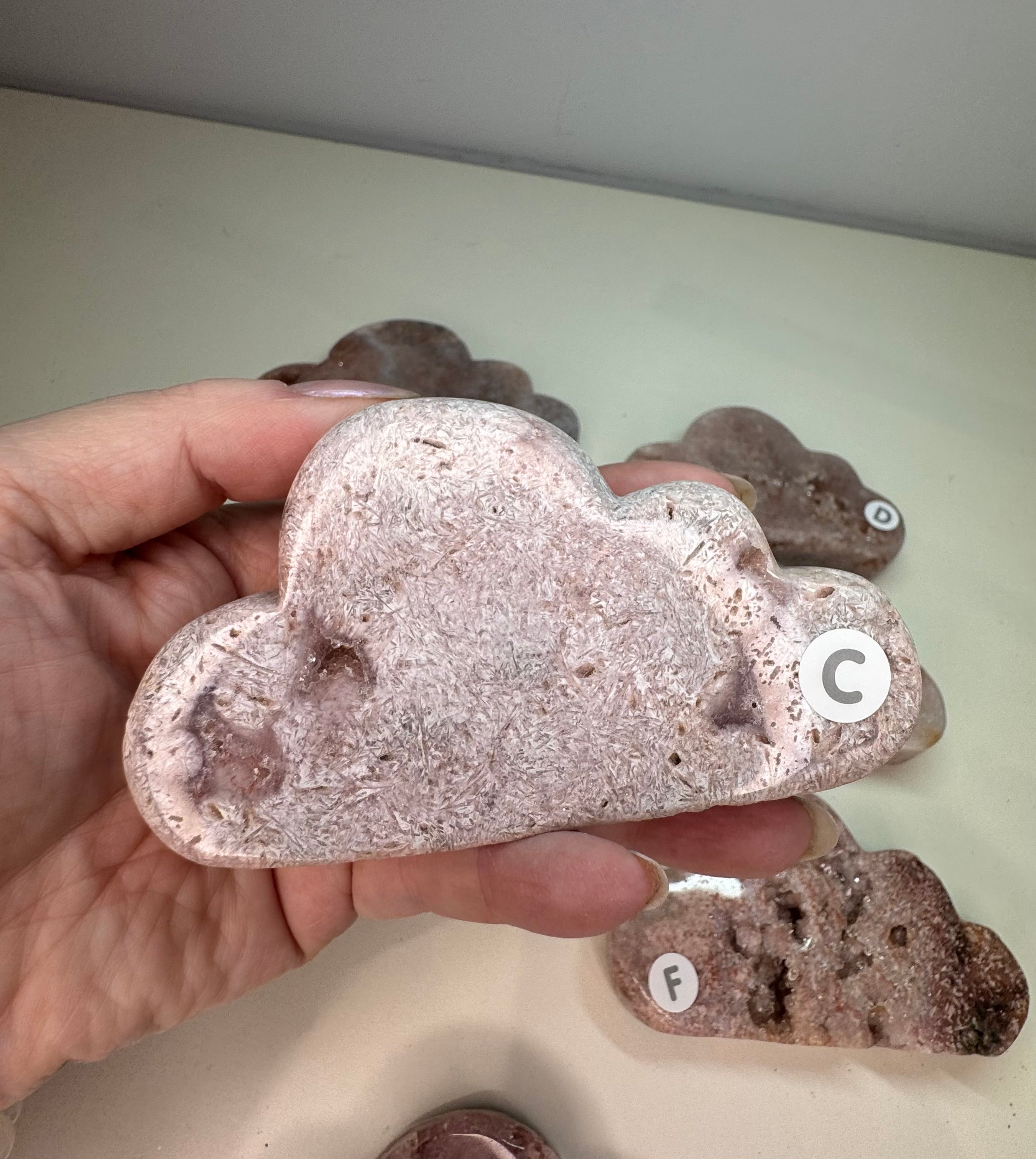 Heart-shaped stone held in a hand with more stones in the background