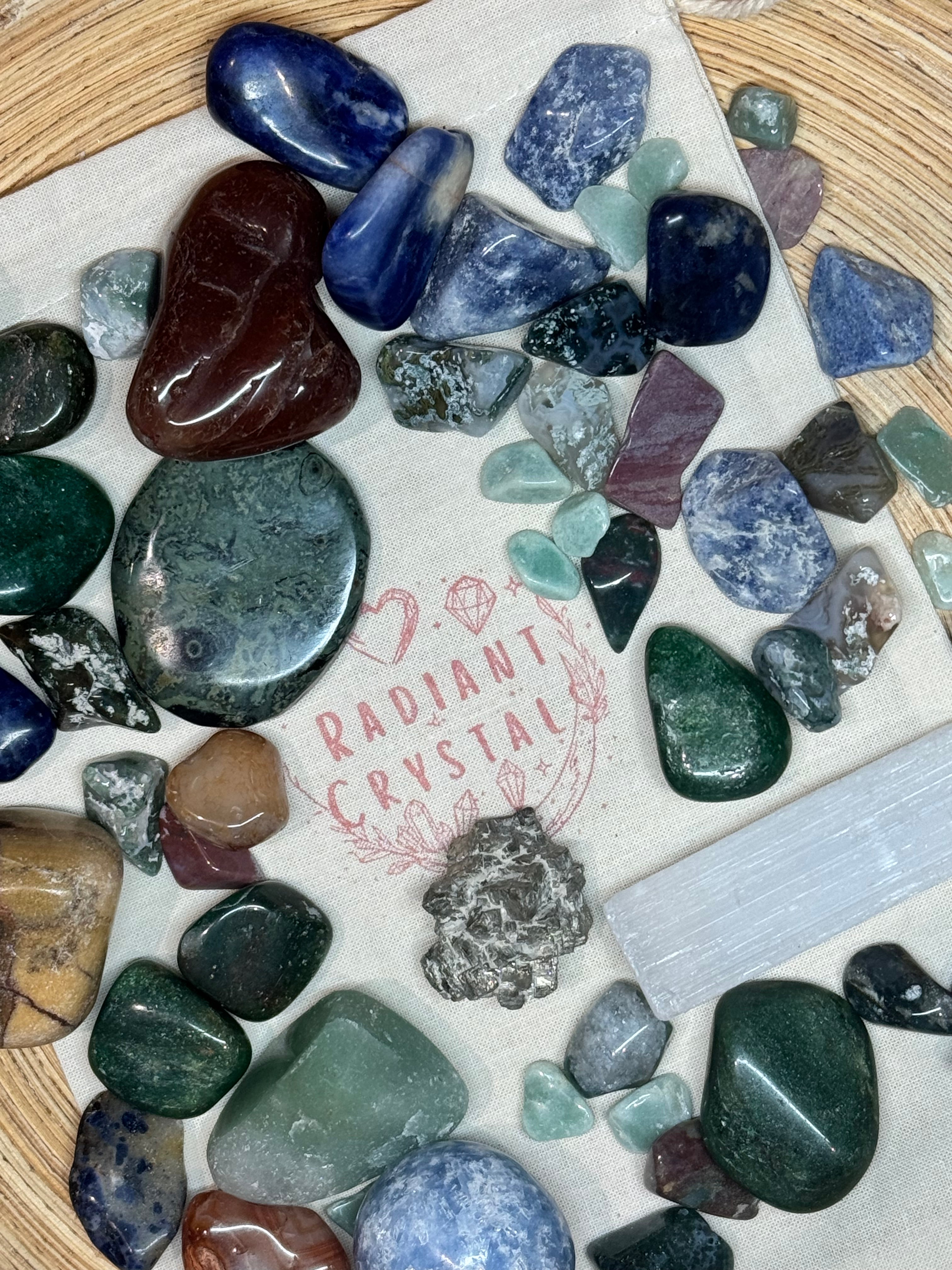 Assorted colorful stones on a marble slab with 'Radiant Crystals' branding.