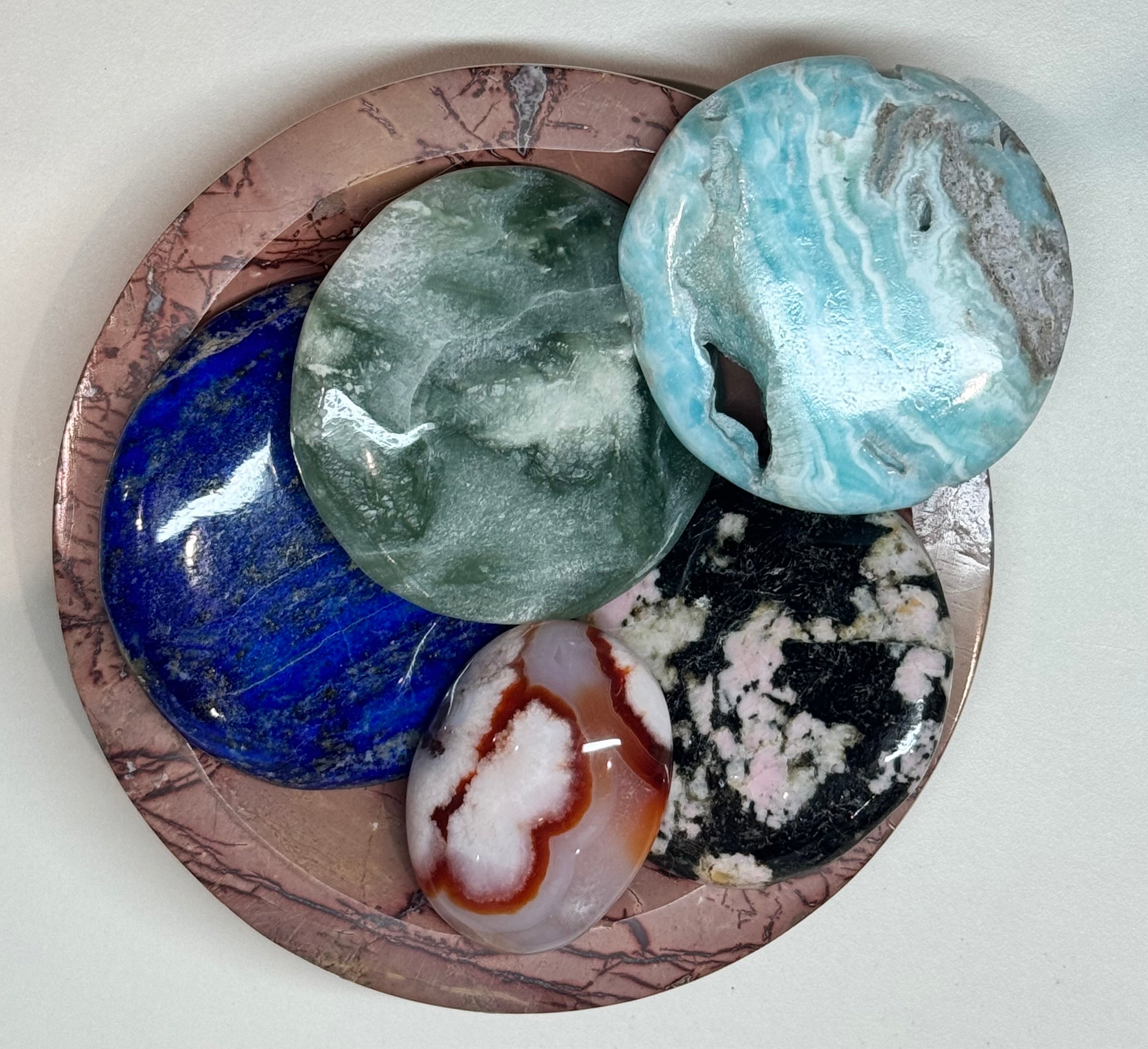 Collection of various stones in a circular stone bowl with marbled surface