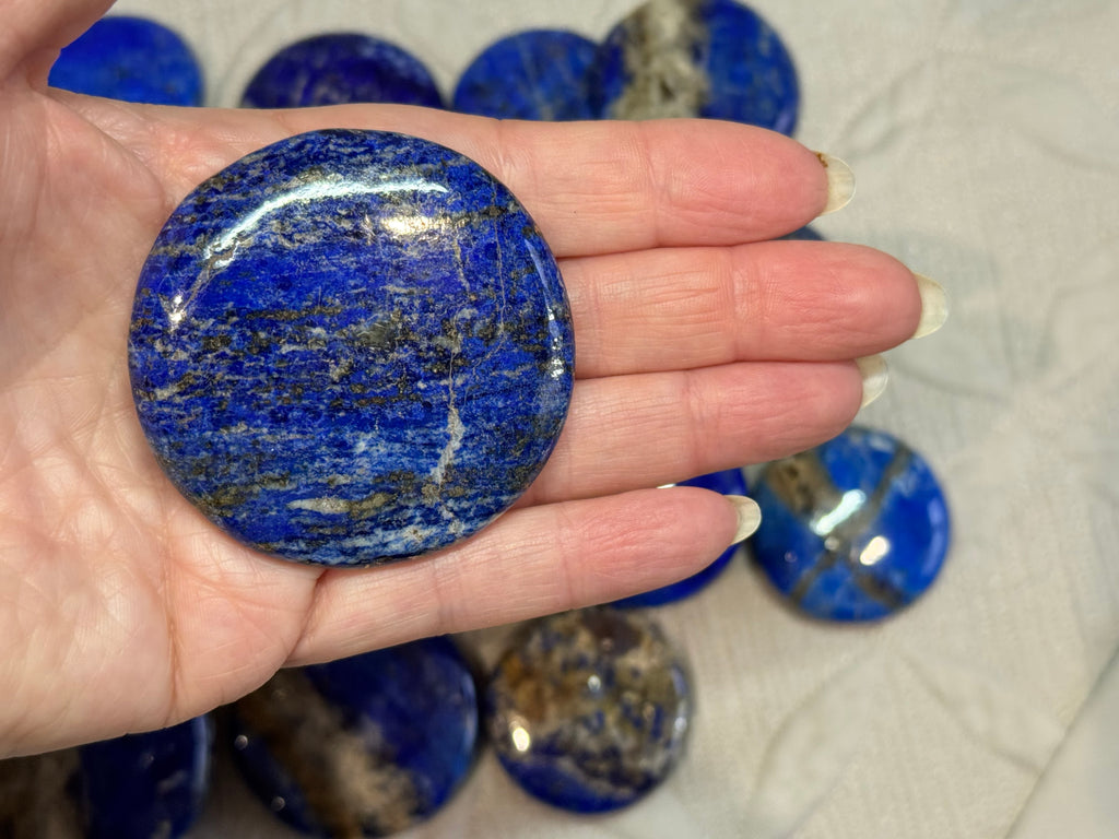 Hand holding a blue stone with more stones in the background