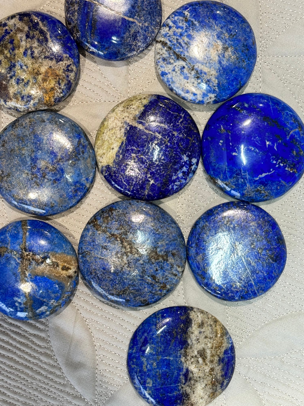 Collection of blue stones with visible patterns on a textured surface