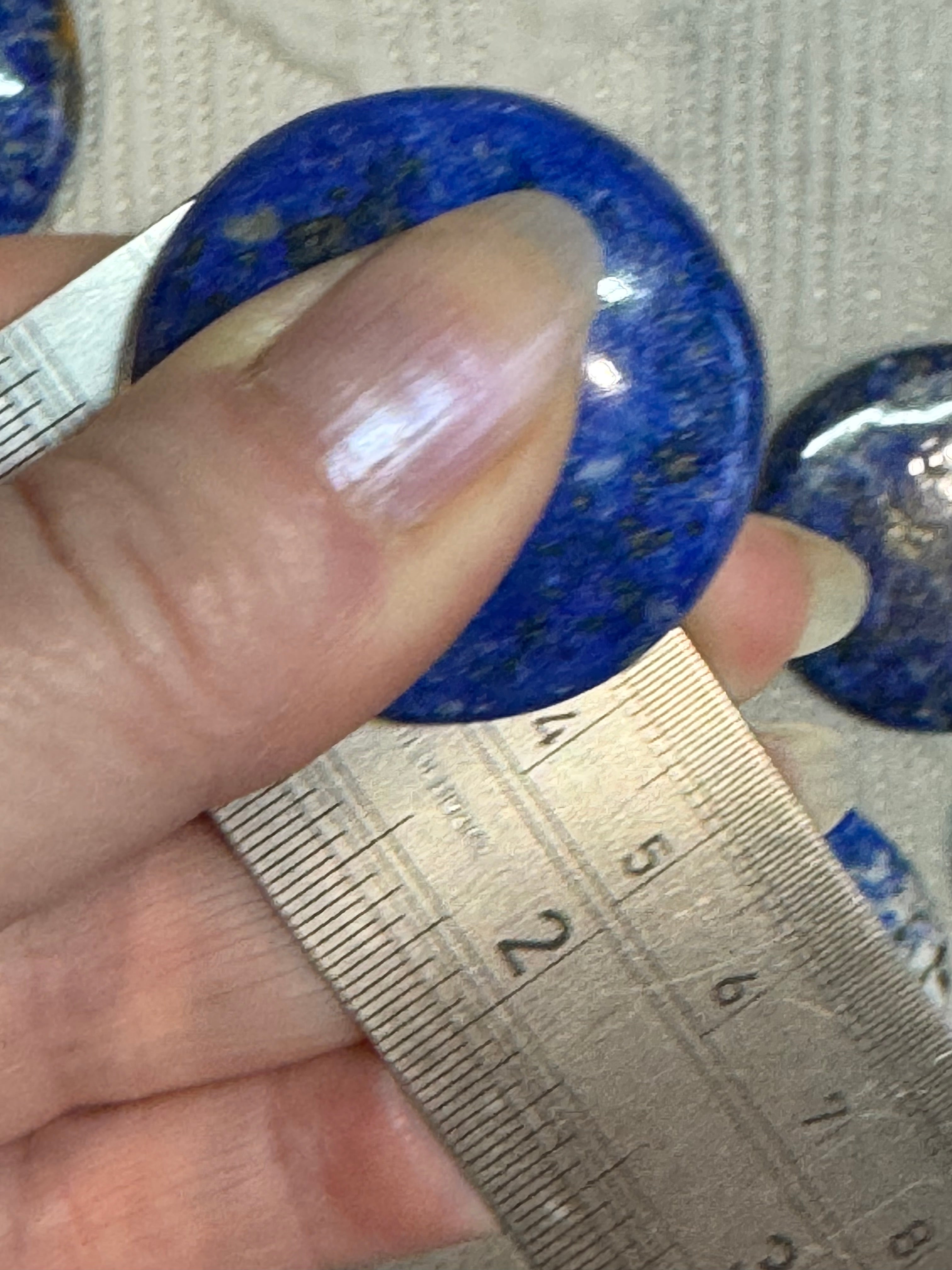 Blue stone with a ruler for scale on a textured surface