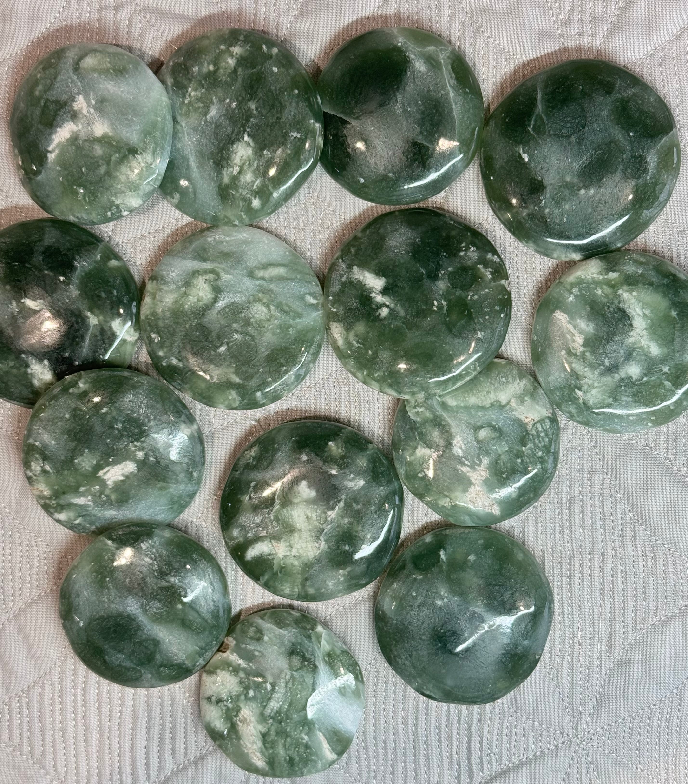 Green marbled stones on a textured white surface