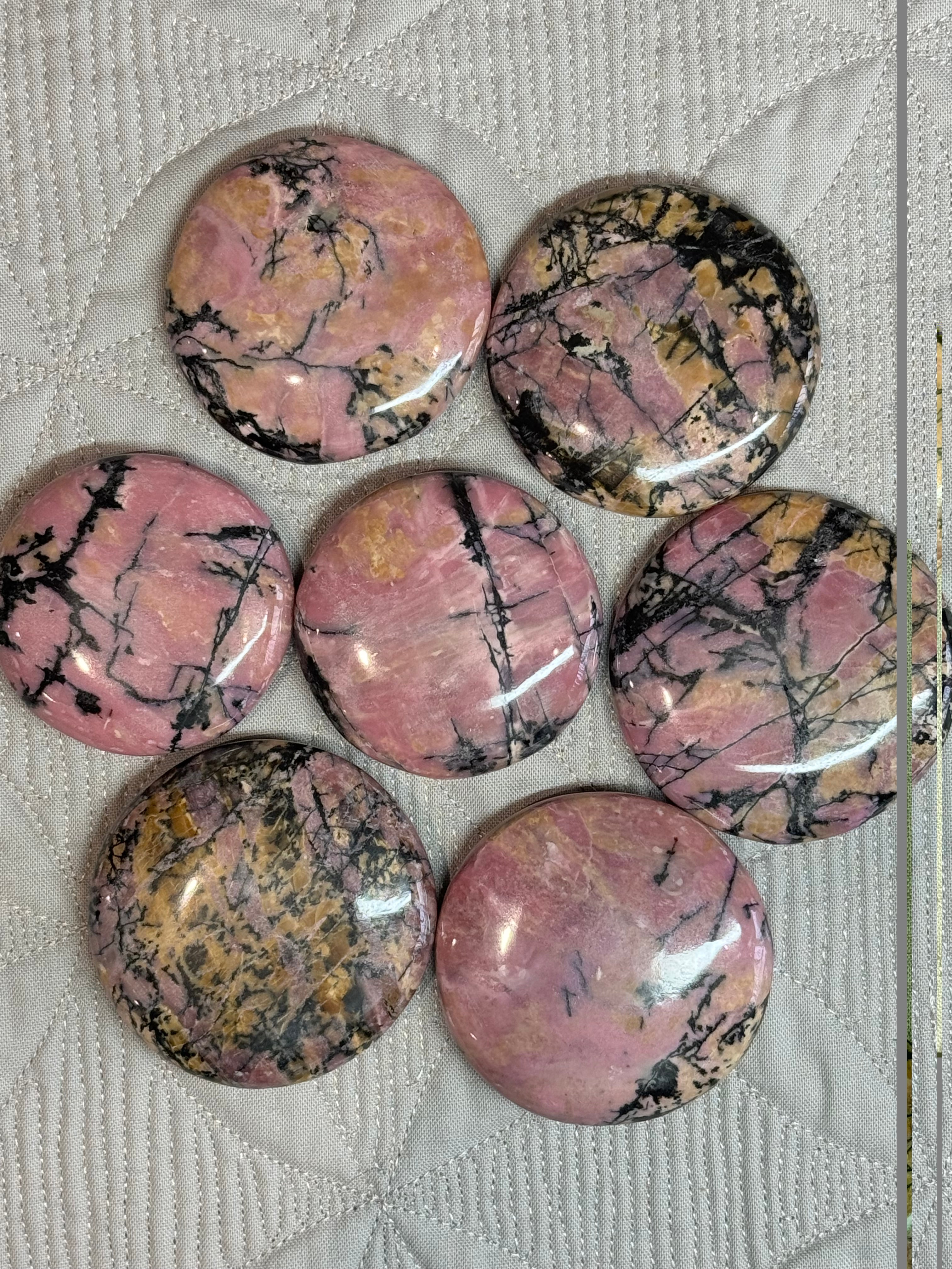 Set of pink and black marbled stones on a textured white surface