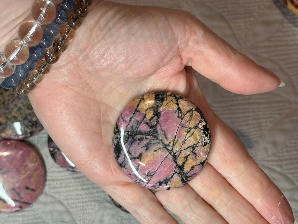 Hand holding a marbled stone with a blurred background