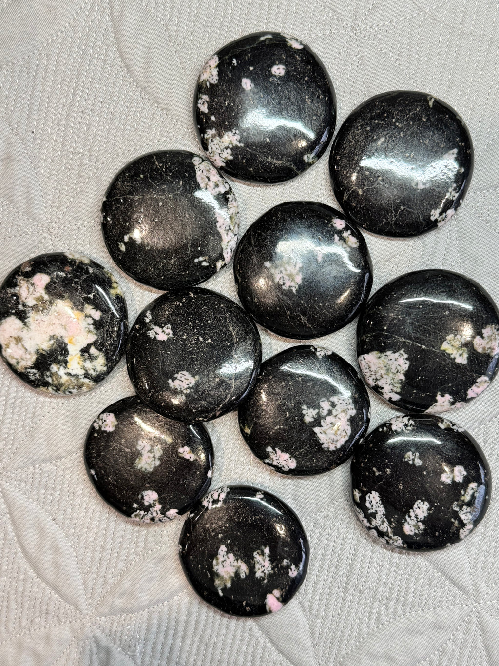 Black stones with white speckles on a textured surface