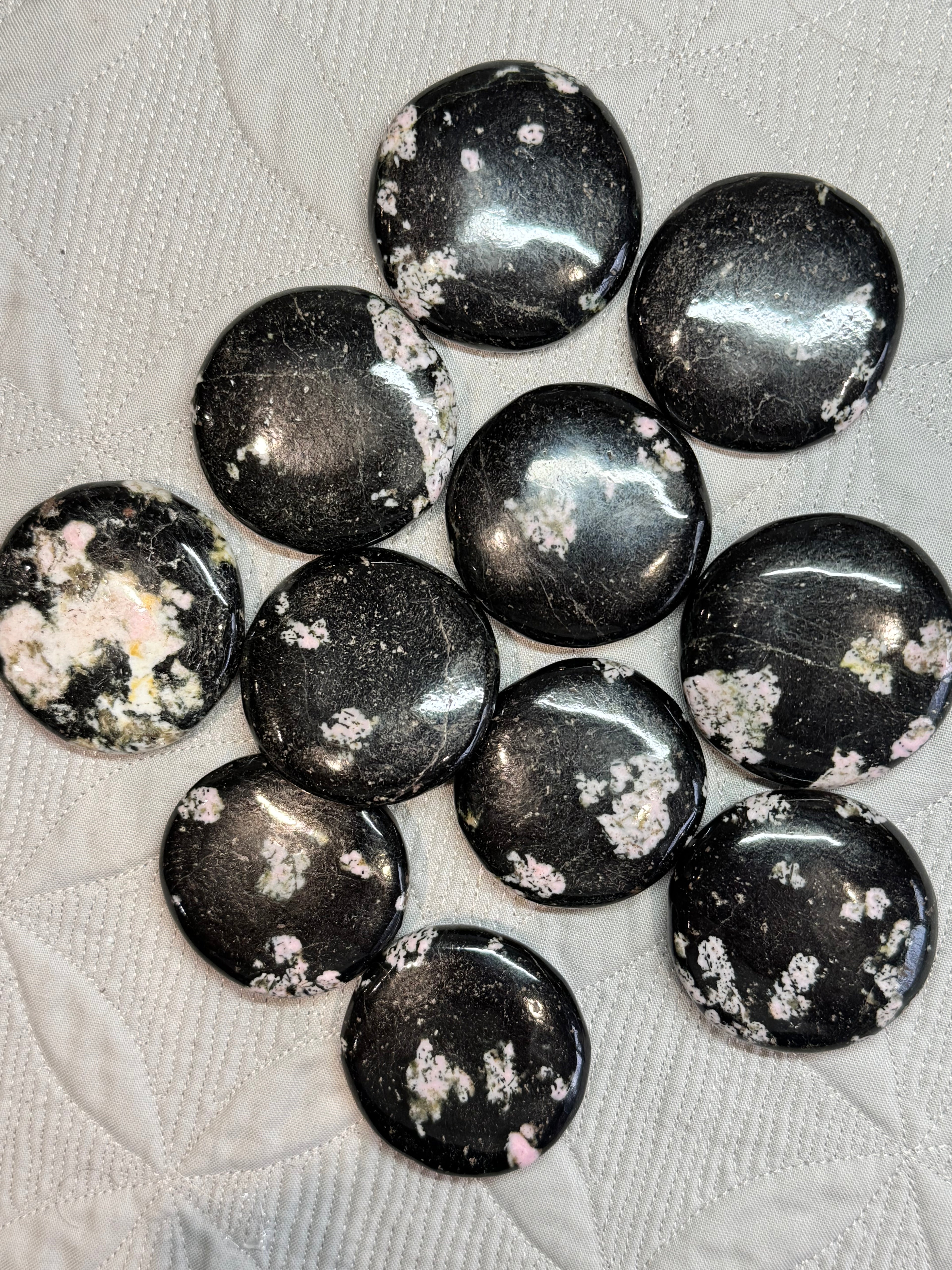Black stones with white speckles on a textured surface