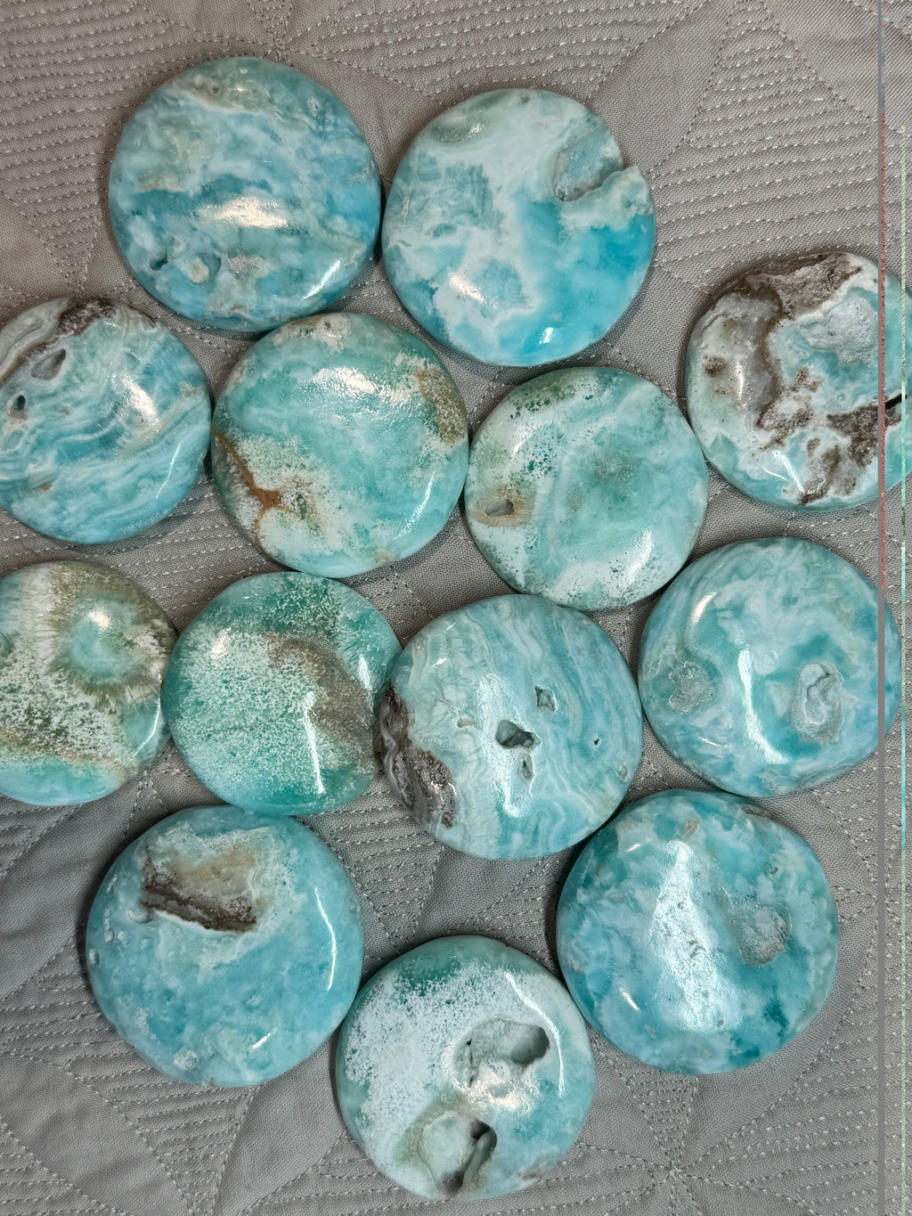 Collection of blue-green marbled stones on a textured surface