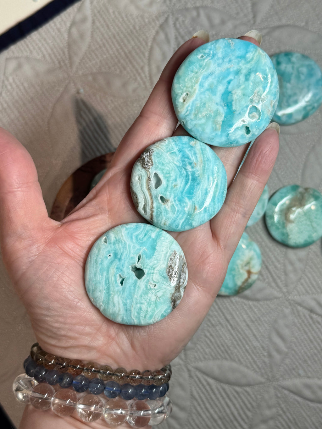 Turquoise stone buttons held in a hand with a textured surface background