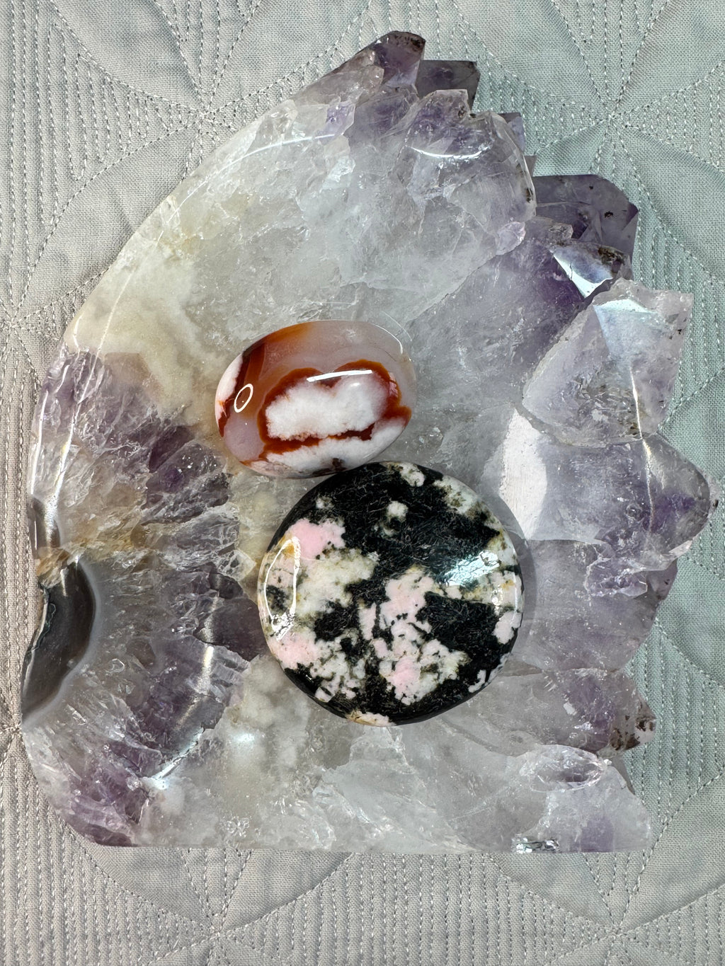 Crystal bowl with stones on, on a textured fabric background