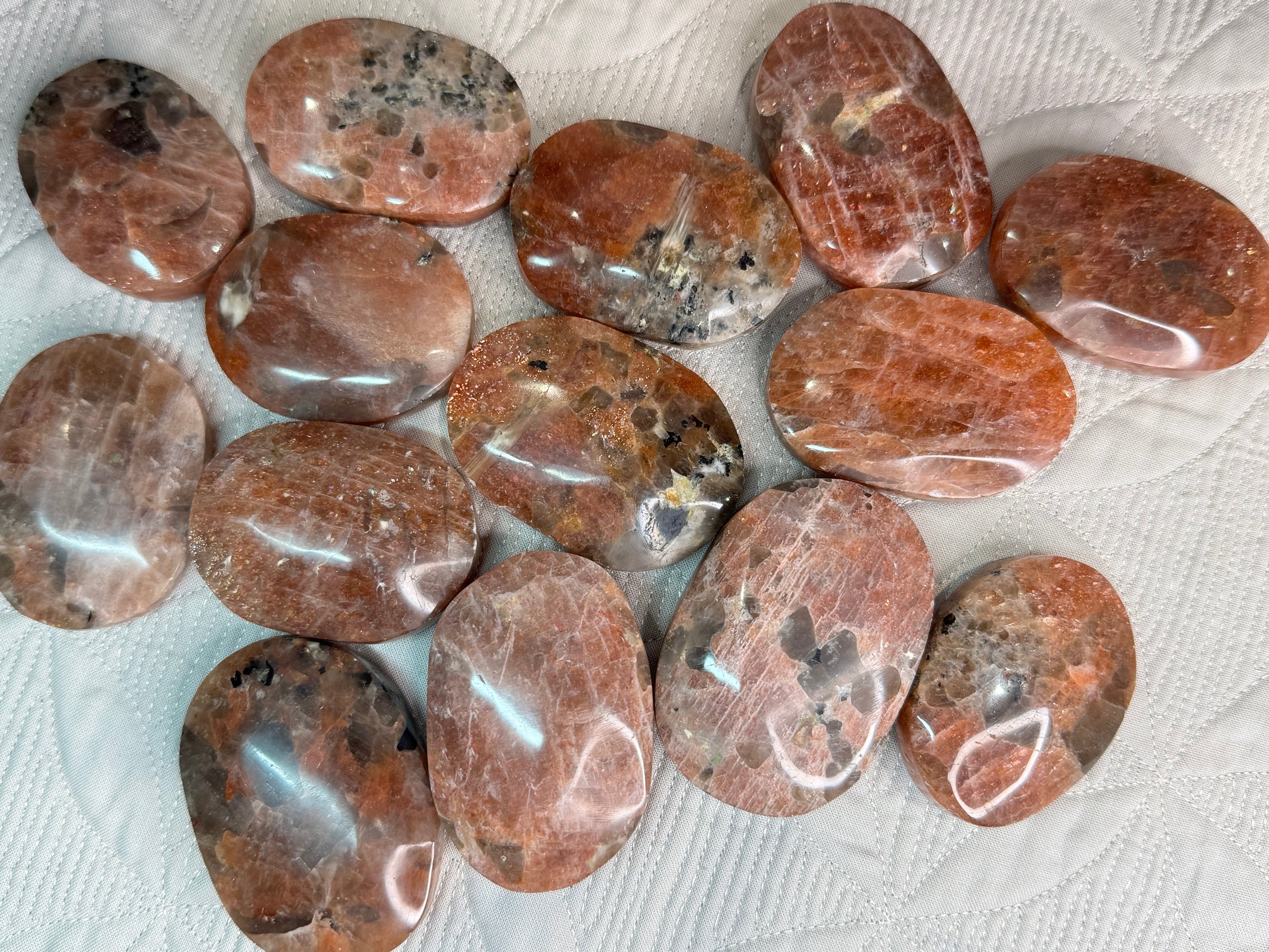 Collection of polished brown stones on a textured white surface