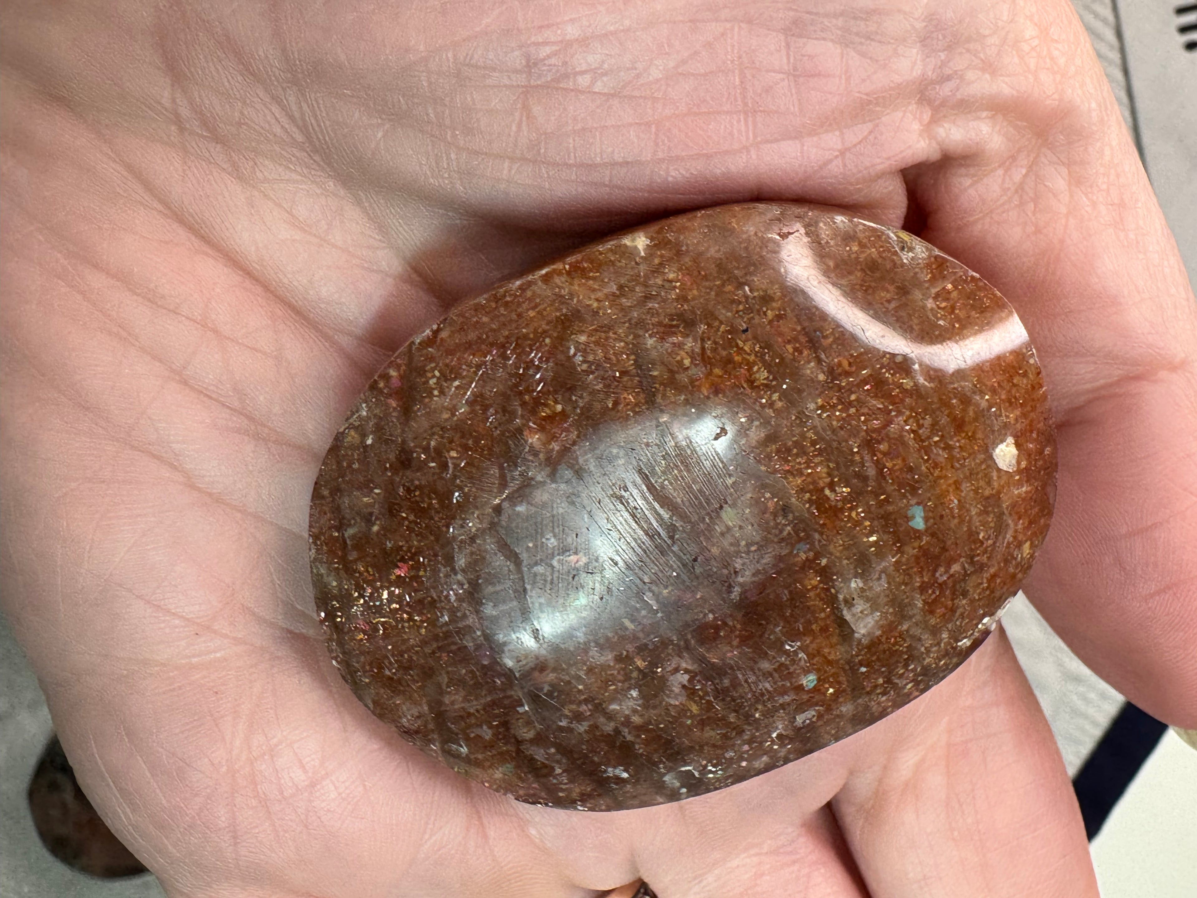 Brown stone held in a hand with a blurred background