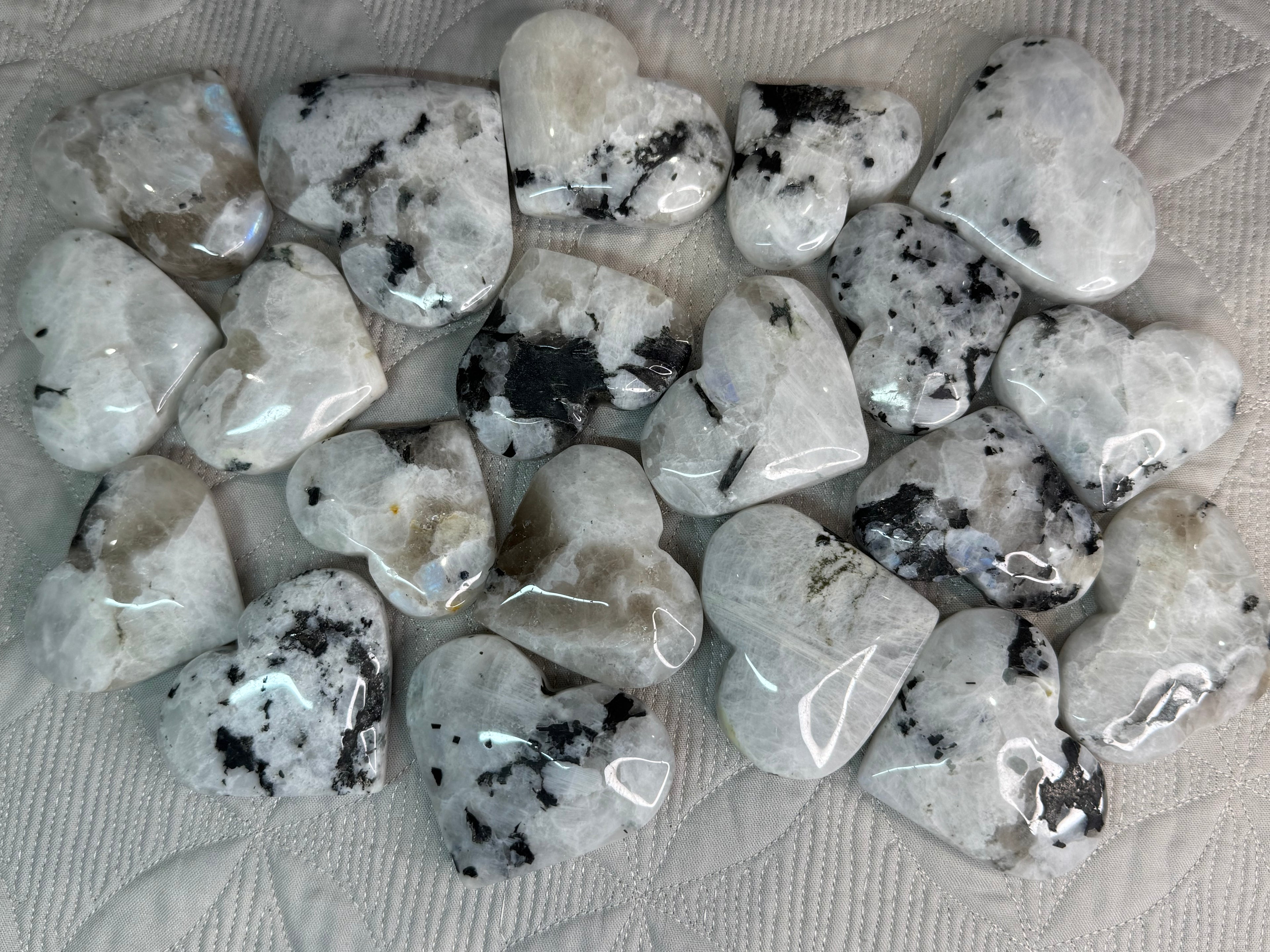 Collection of polished stones with black inclusions on a textured surface
