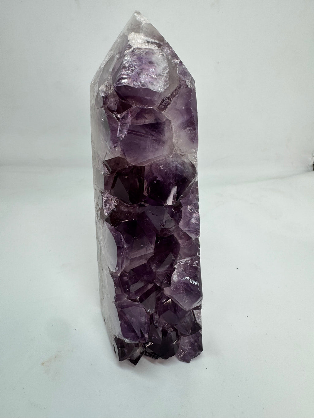 Amethyst crystal point on a white background